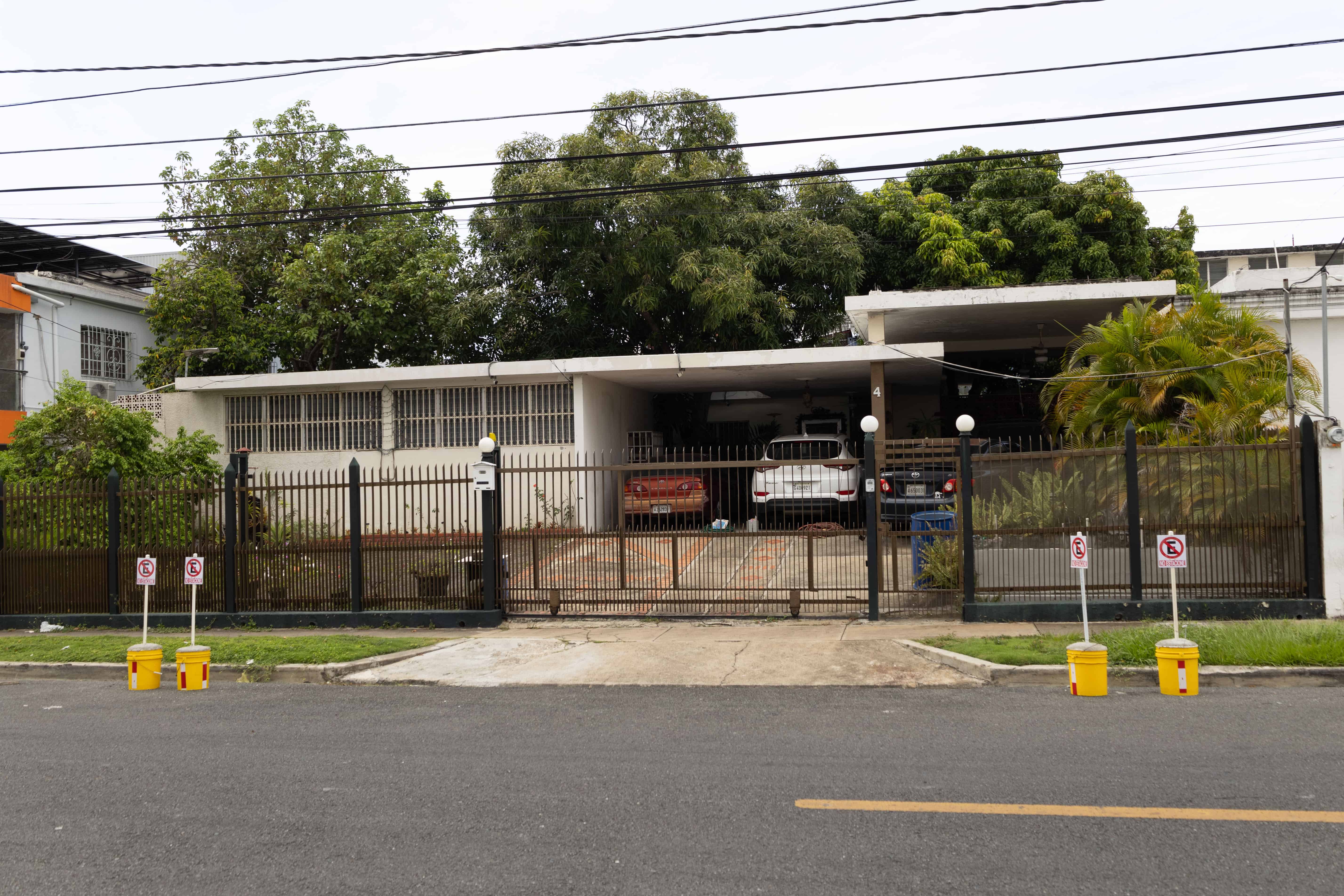 Una vivienda en Los Prados pone obstáculos y letreros en la vía pública para evitar que se estaciones en la parte frontal. 