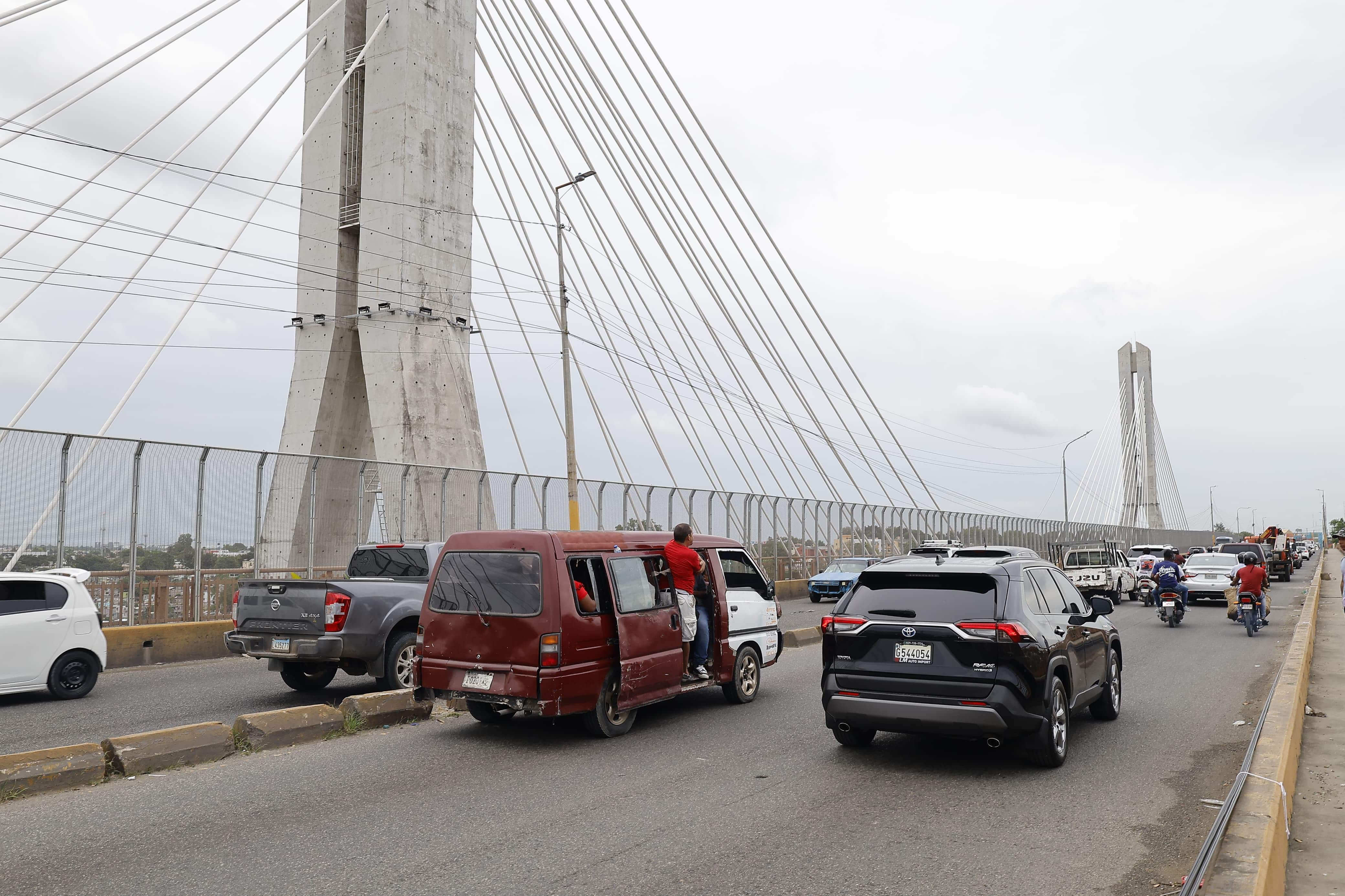 Vehículos transitan en el puente de la 17, donde en la mañana cayeron cuatro postes del tendido eléctrico. 