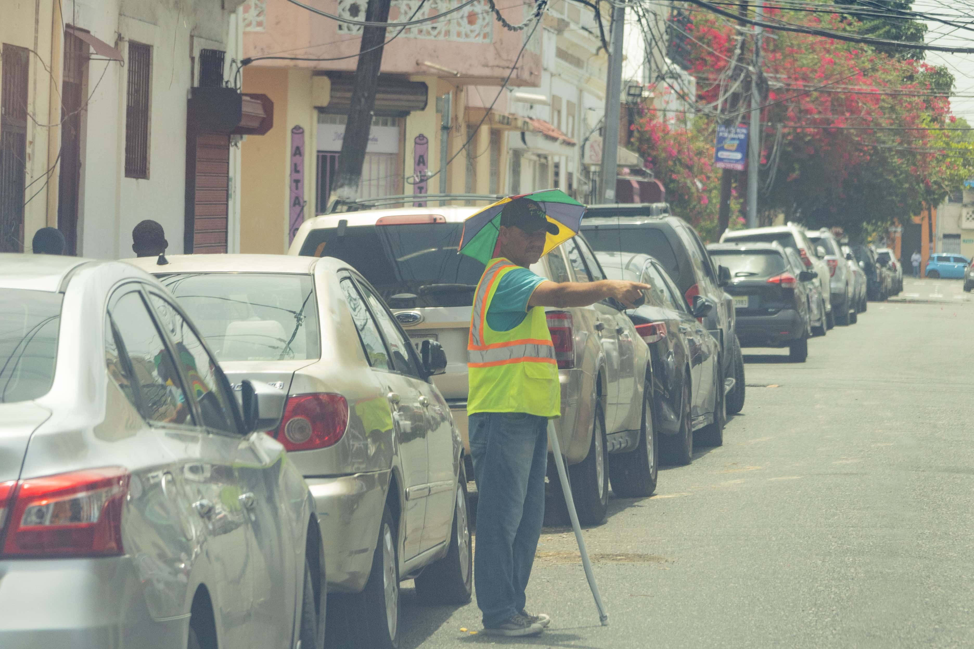 Un parqueador muestra un espacio para luego cobrar.