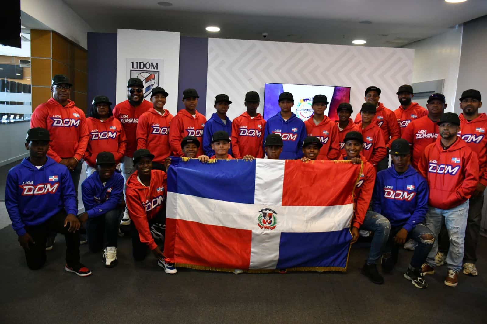 Integrantes del equipo dominicano con la bandera dominicana. El equipo competirá en la Serie del Caribe Kids 2025. El equipo fue abanderado este miércoles 2 de julio de 2025, en el Séptimo Cielo del Estadio Quisqueya Juan Marichal.
