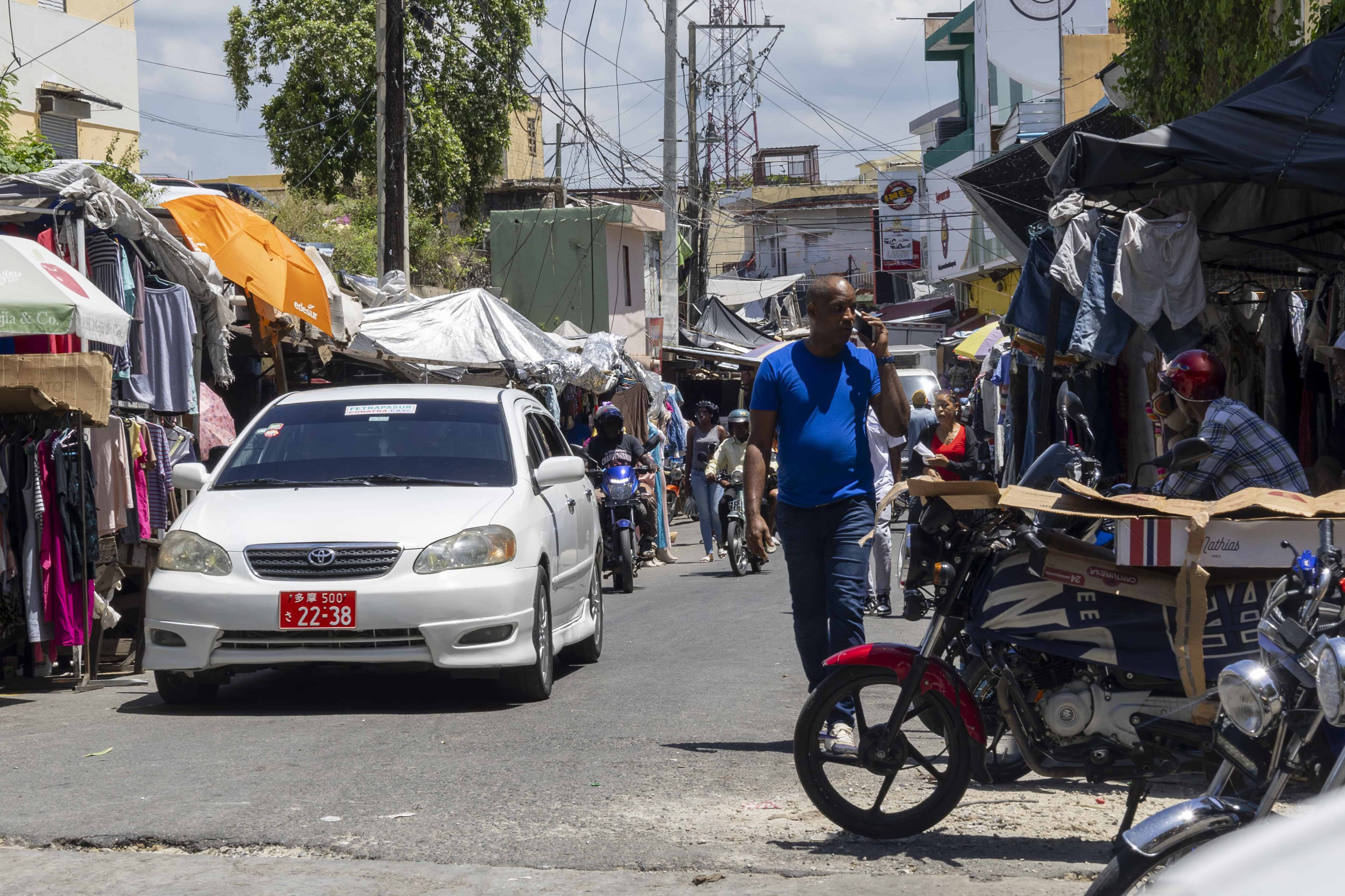 Las aceras son ocupadas por comerciantes y vehículos.