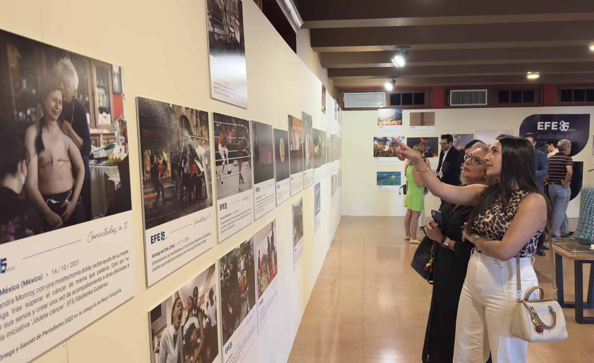 Personas recorren la exposición de la Agencia EFE, compuesta por fotografías de sus más de ocho décadas de historia, en el Centro Español, en Santiago (República Dominicana).