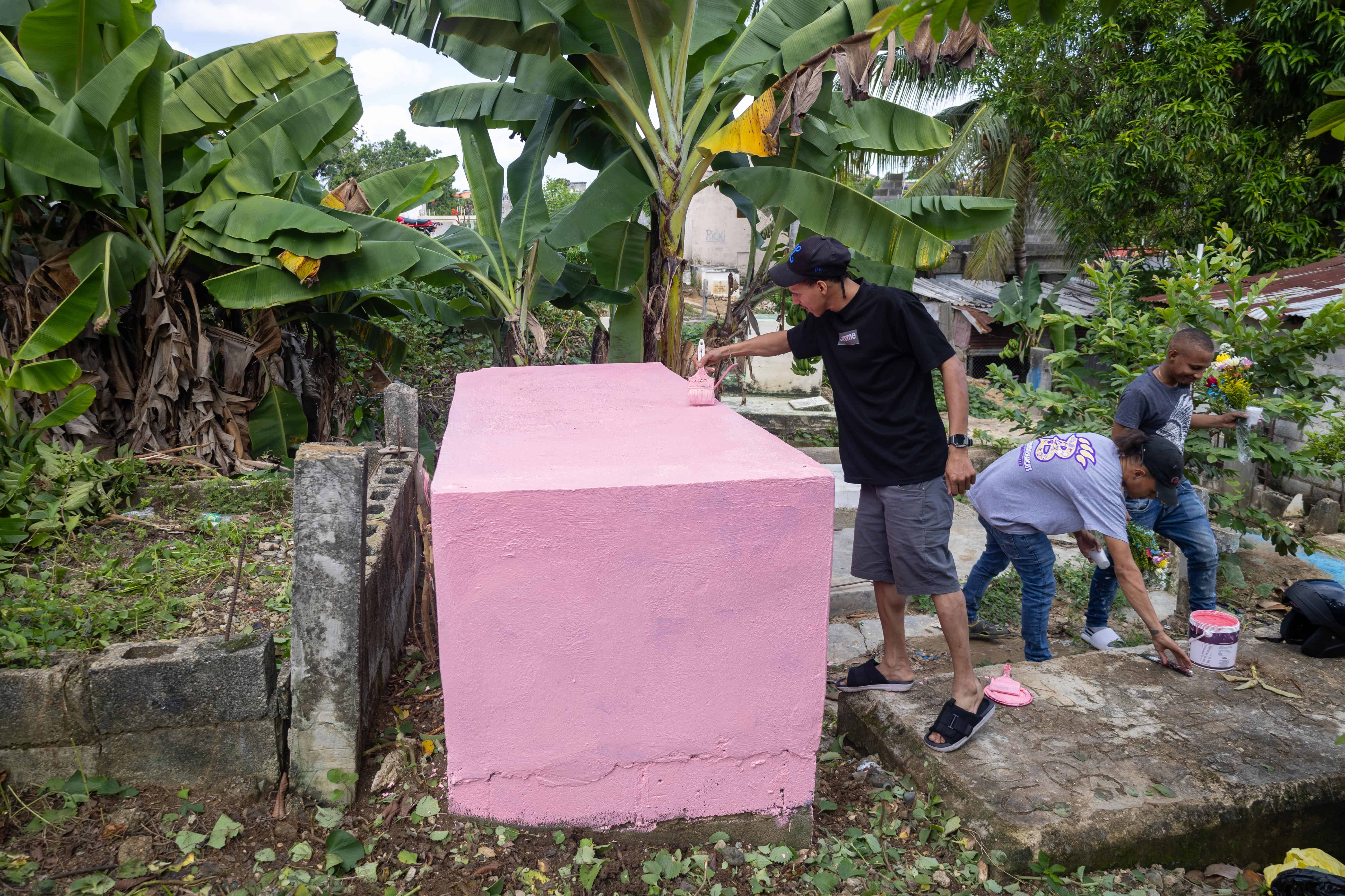 Familiares pintan la tumba de su padre en su día especial. <br>