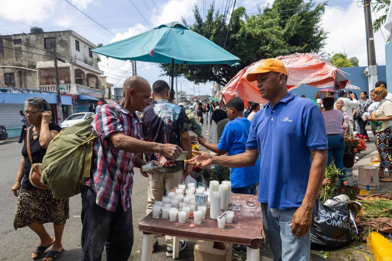 Hombre comprando velones frente al cementerio Cristo Rey en el Distrito Nacional.