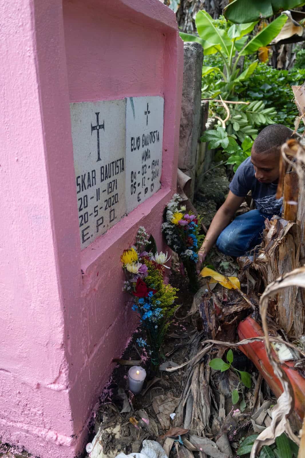 Un hijo coloca flores en la tumba de su papá.