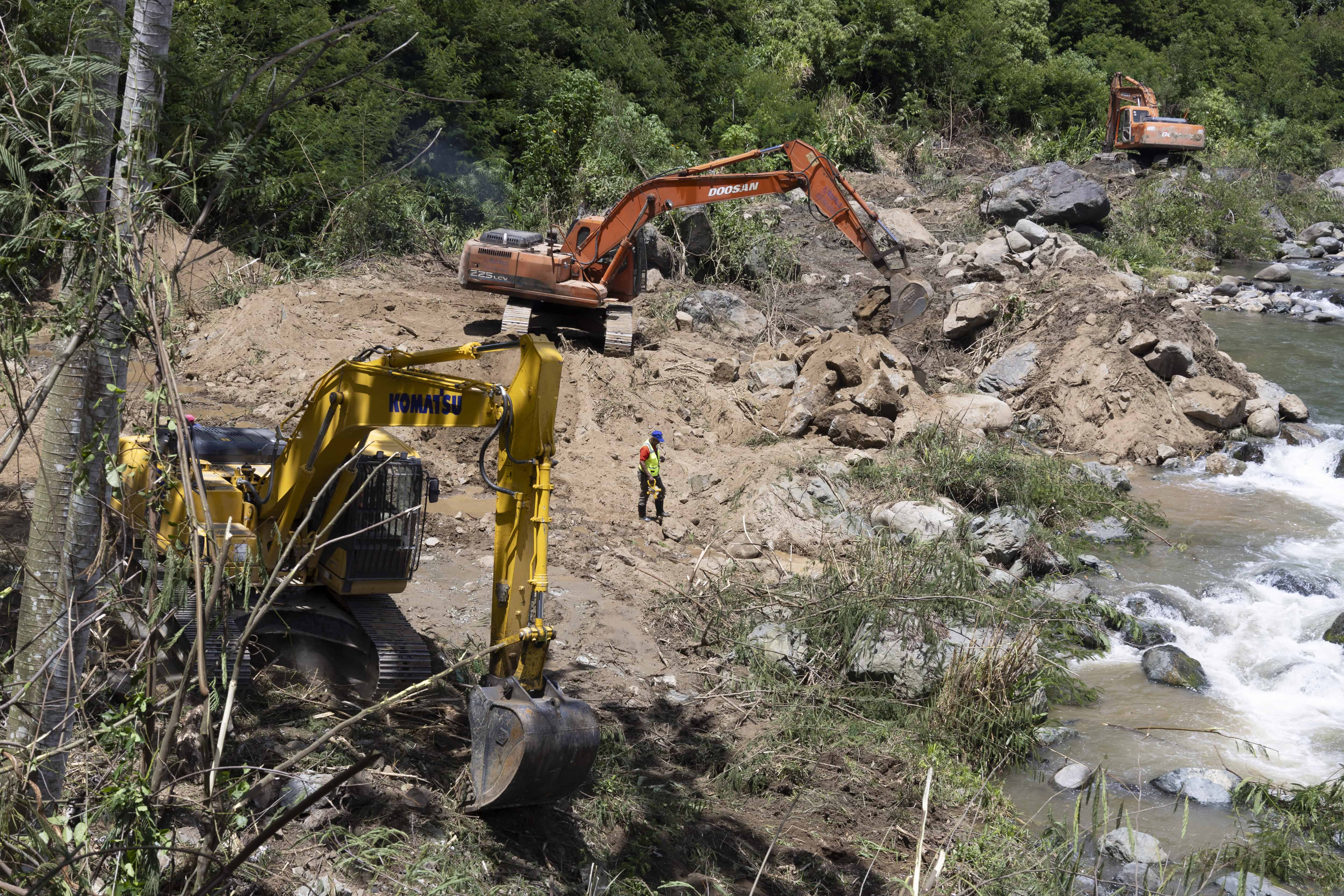 Un operario camina entre las maquinarias que trabajan parte de las inmediacioens del río Yaque del Norte para la instalación de una toma de agua.
