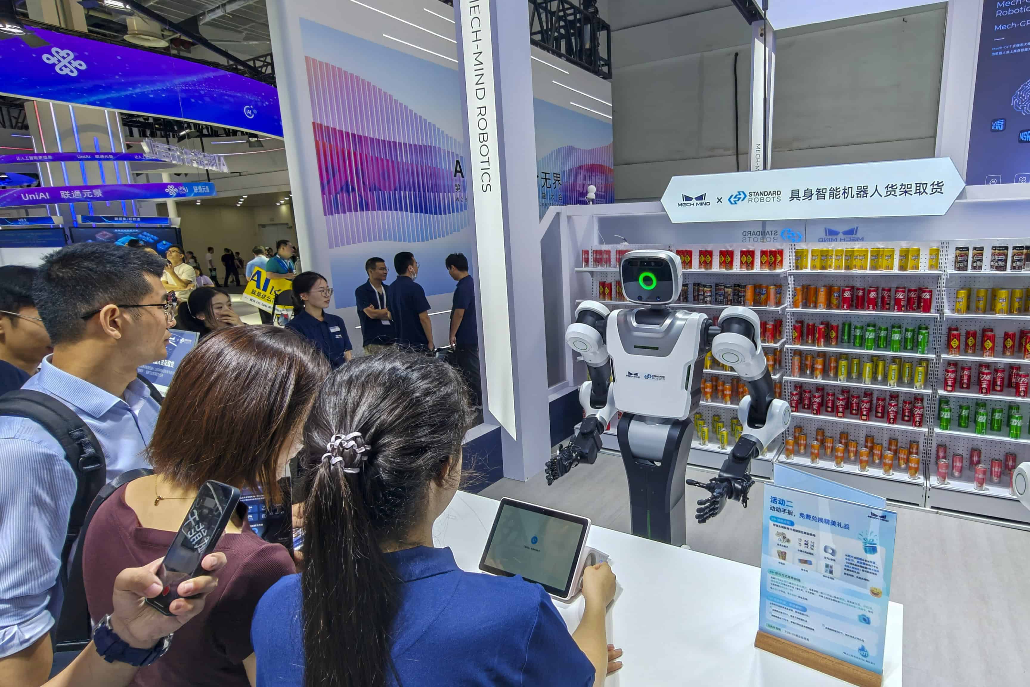 Un robot camarero atiende al público suministrándole bebidas en la feria de IA de Shanghai. 