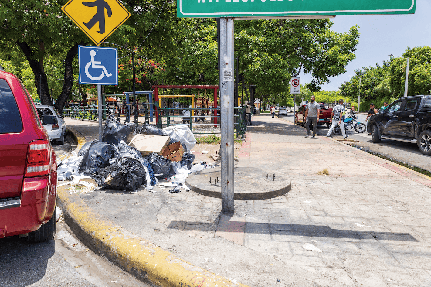 Rampa obstaculizada con basura y un vehículo estacionado.