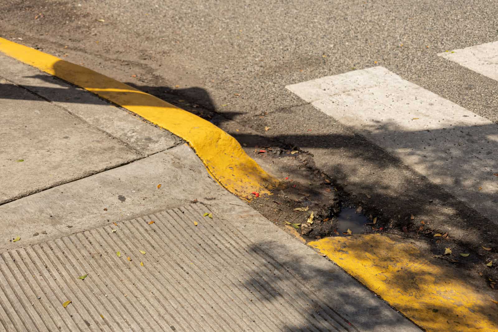 Una rampa para personas con discapacidad con un hoyo que dificulta su uso.