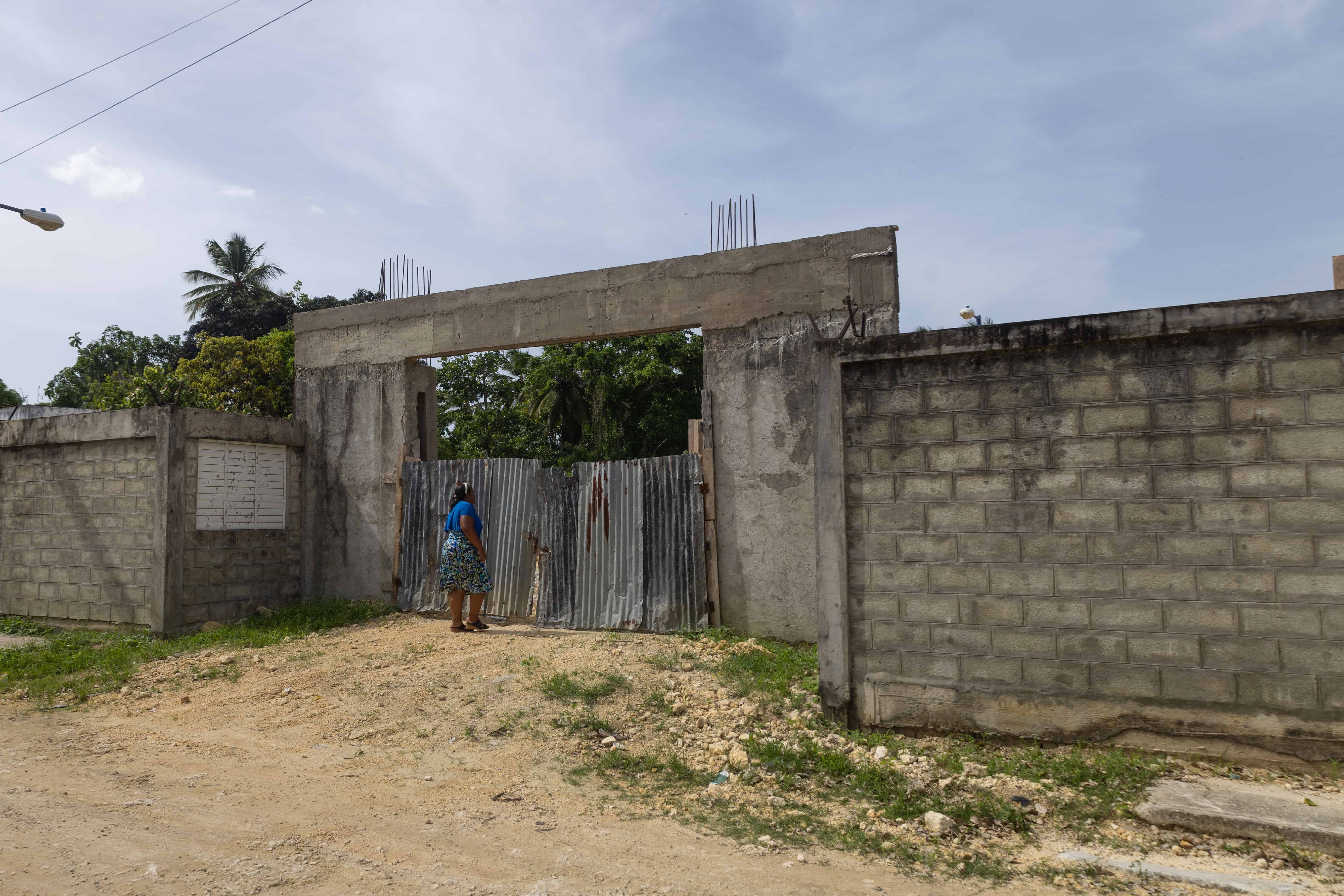 Odaliza Santana observa la construcción cerrada desde la fachada, aún sin terminar.
