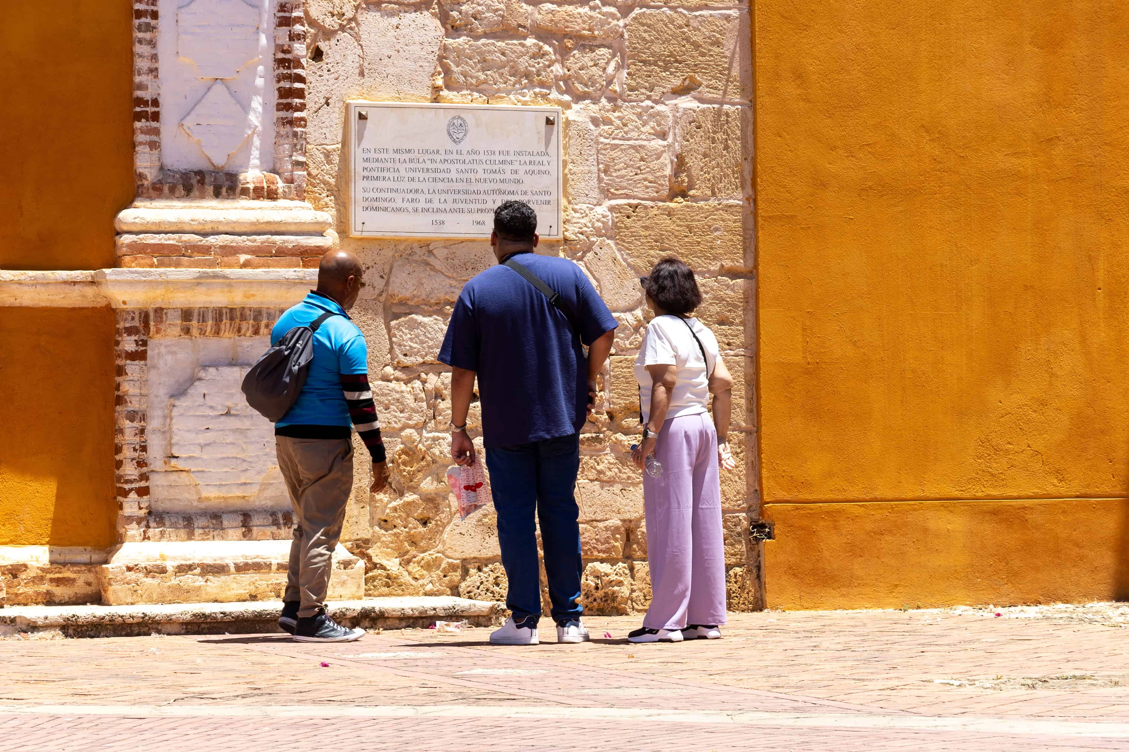 Un guía turístico muestra la placa que identifica a la Iglesia y Convento de los Dominicos como la sede de la Real y Pontificia Universidad Santo Tomás de Aquino (1538).