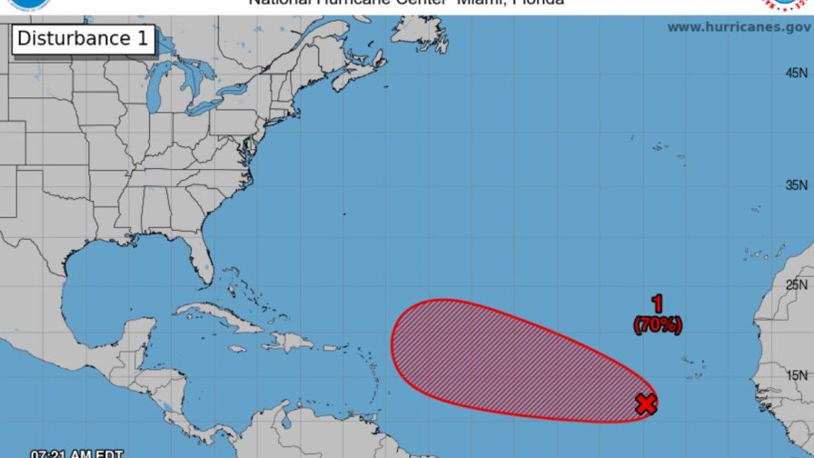Imagen fotorrealista de un satélite observando una gran onda tropical girando sobre las aguas cálidas del Océano Atlántico, con nubes densas y formaciones ciclónicas incipientes. Iluminación dramática y detalles nítidos.
