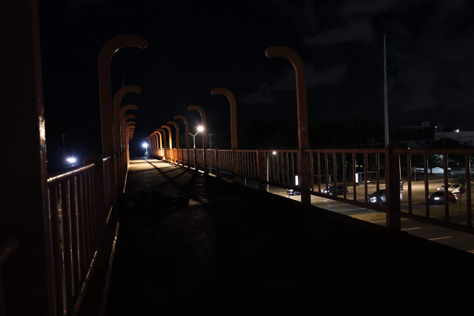 Peatonal en la Av. JFK sin iluminación y un indigente usándolo como refugio.