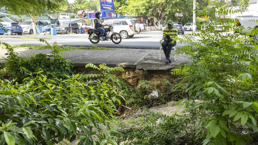Riesgo latente en intersección transitada: vehículos y peatones en peligro por mal estado de aceras