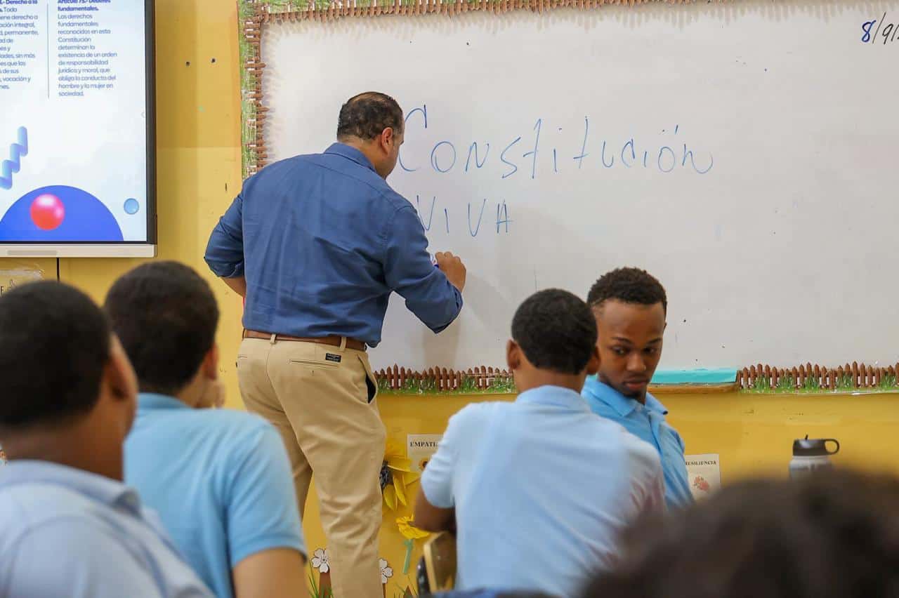 Pablo Ulloa, escribiendo en un pizarrón en el primer día de inicio de docencia sobre deberes y derechos ciudadanos en las escuelas públicas. 