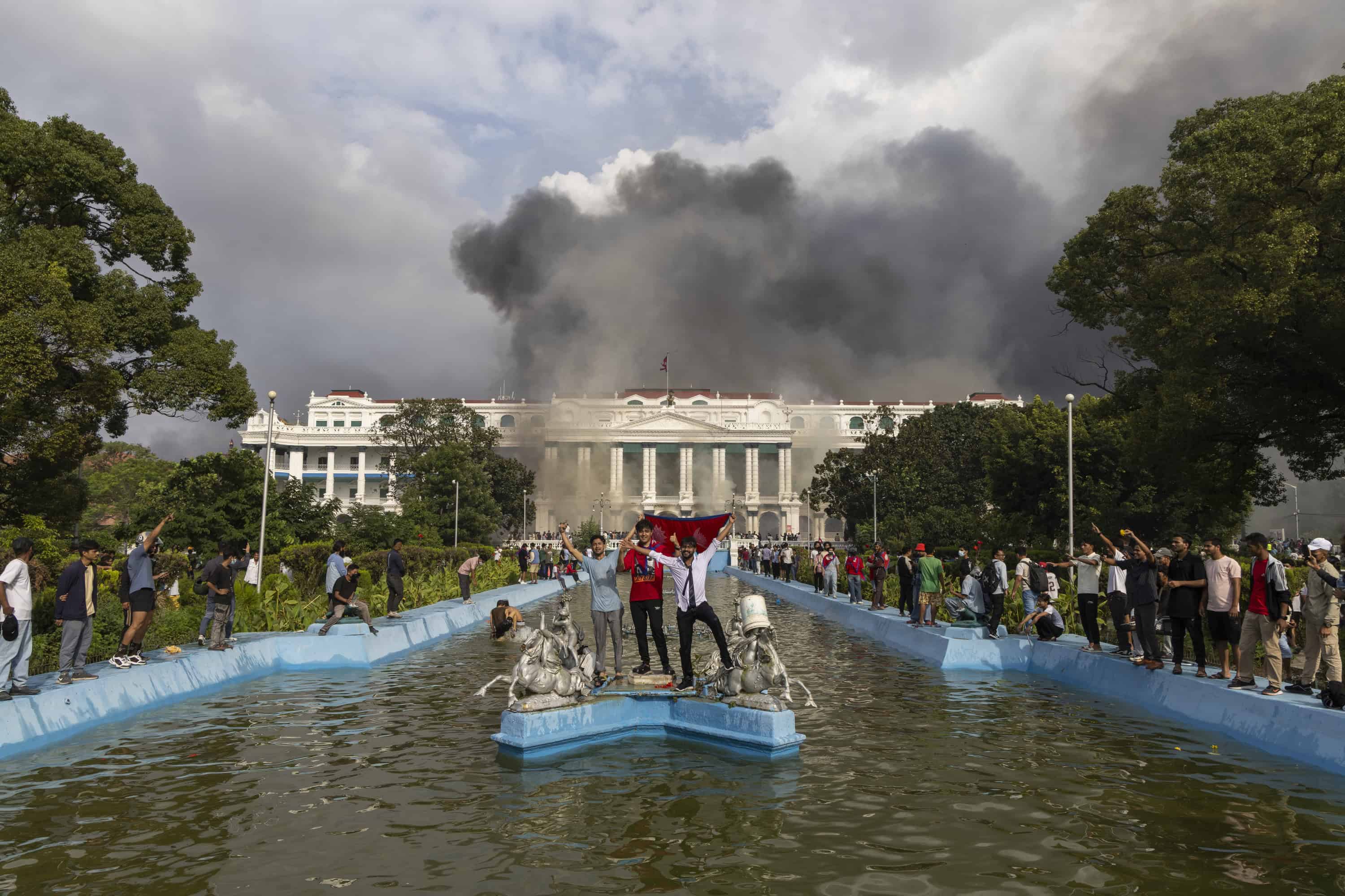 Los manifestantes se reúnen frente al palacio Singha Durbar, que alberga los edificios del gobierno y del parlamento, después de que los manifestantes asaltaran las instalaciones durante manifestaciones violentas en Katmandú, Nepal, el 9 de septiembre de 2025. Al menos 19 personas murieron y docenas resultaron heridas el 8 de septiembre durante manifestaciones contra la corrupción y una prohibición de las redes sociales del gobierno. (Protestas)
