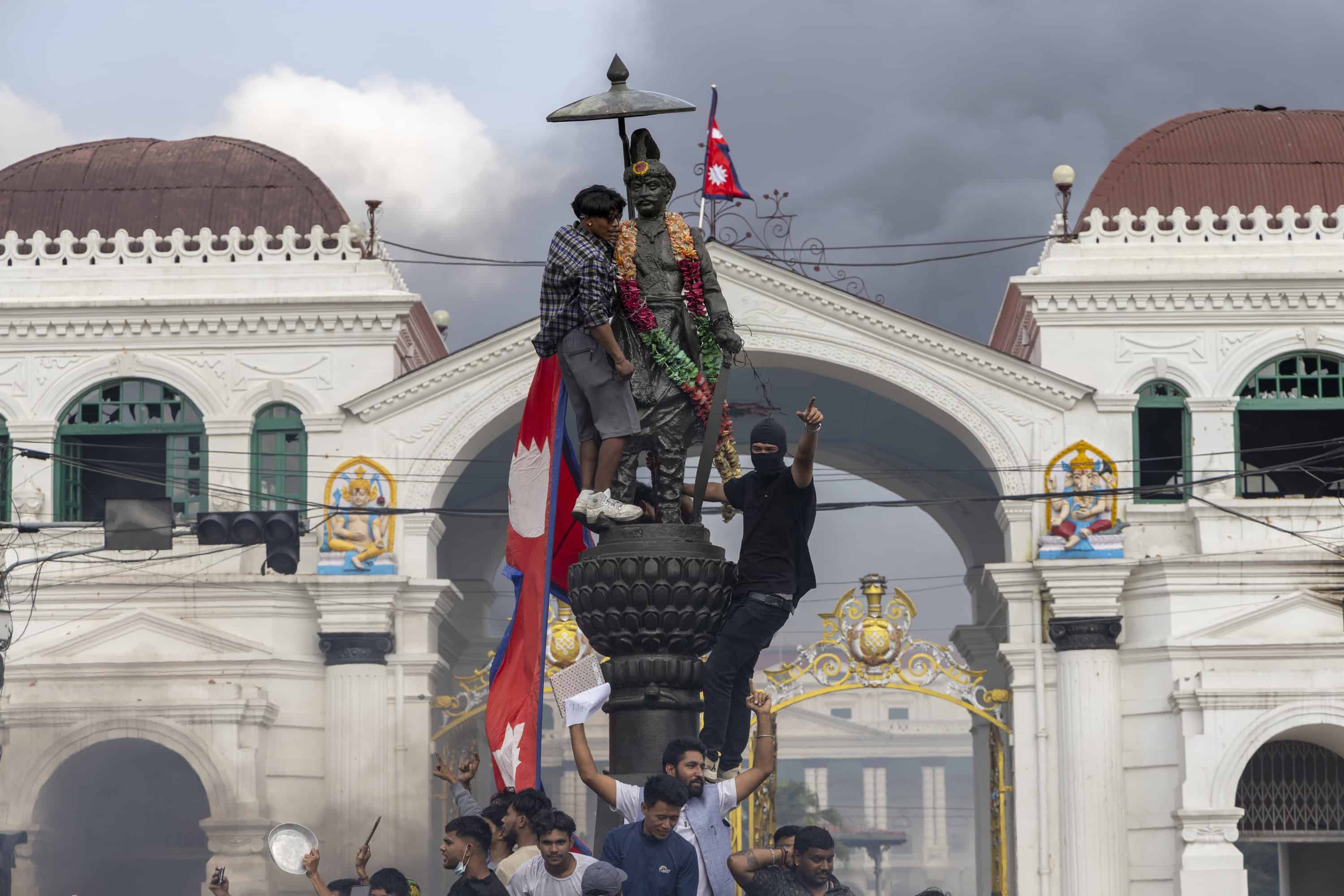 Los manifestantes instalan la bandera nacional en la estatua del primer rey de Nepal, Prithvi Narayan Shah, durante manifestaciones violentas en Katmandú, Nepal, el 9 de septiembre de 2025. Al menos 19 personas murieron y docenas resultaron heridas el 8 de septiembre durante manifestaciones contra la corrupción y una prohibición de las redes sociales del gobierno. (Protestas)