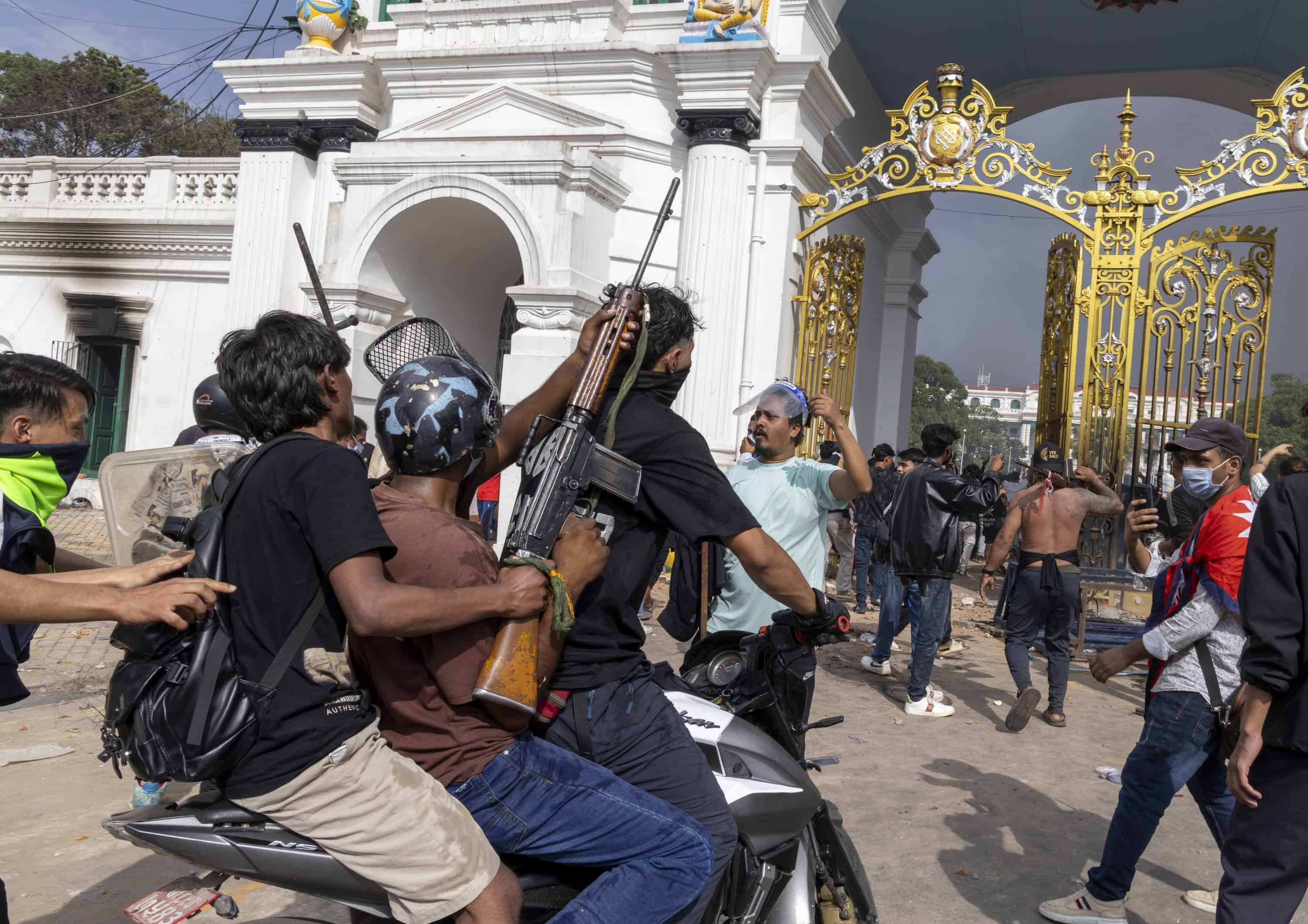 Un hombre lleva un arma saqueada por la policía mientras asalta el palacio Singha Durbar, que alberga edificios del gobierno y del parlamento, durante manifestaciones violentas en Katmandú, Nepal, el 9 de septiembre de 2025. Al menos 19 personas murieron y docenas resultaron heridas el 8 de septiembre durante manifestaciones contra la corrupción y una prohibición de las redes sociales del gobierno. (Protestas)