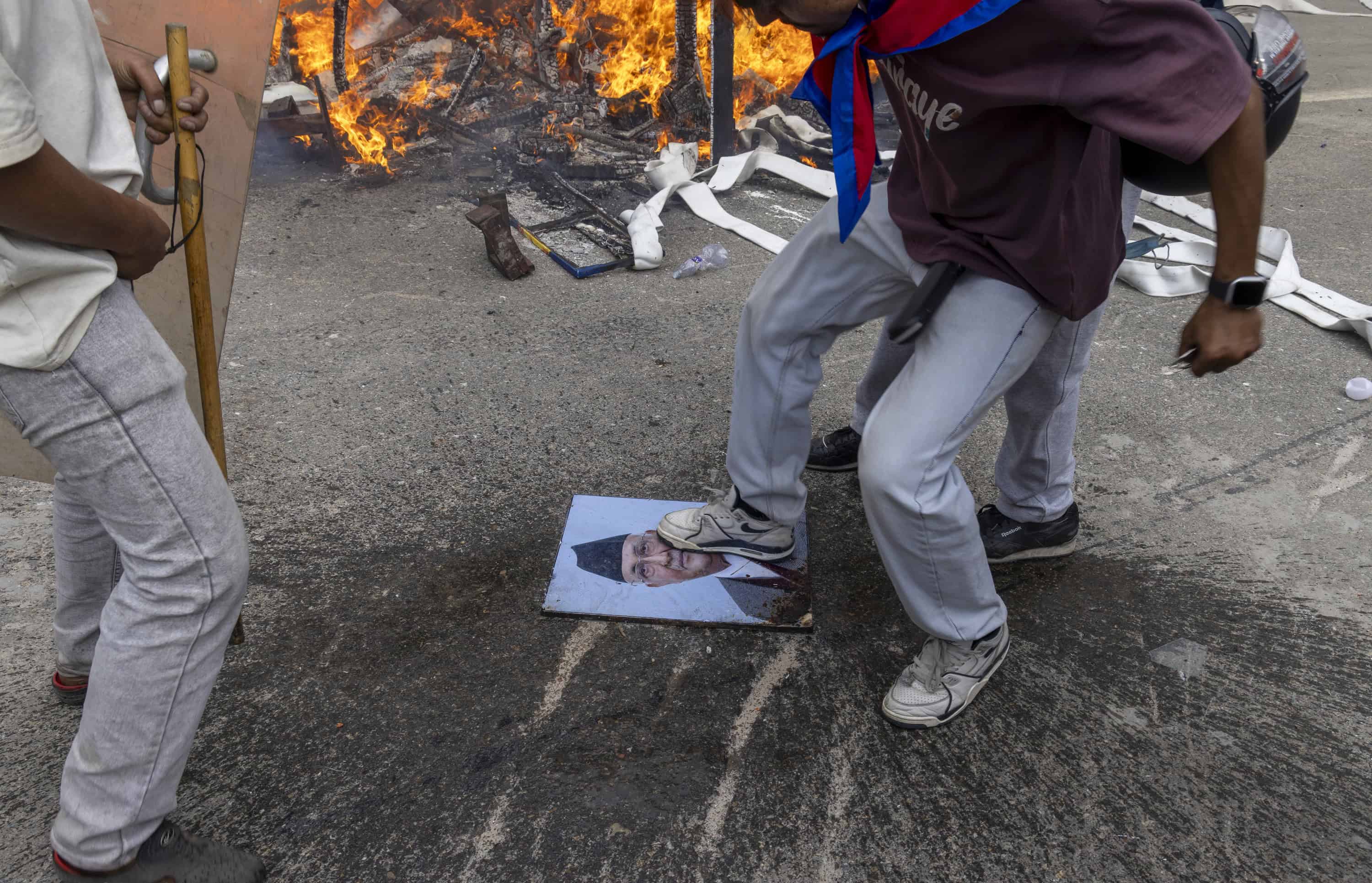 Los manifestantes pisan una foto del primer ministro dimitido K.P. Sharma Oli mientras asalta el palacio Singha Durbar, que alberga los edificios del gobierno y del parlamento, durante manifestaciones violentas en Katmandú, Nepal, el 09 de septiembre de 2025. Al menos 19 personas murieron y docenas resultaron heridas el 8 de septiembre durante manifestaciones contra la corrupción y una prohibición de las redes sociales del gobierno. (Protestas)