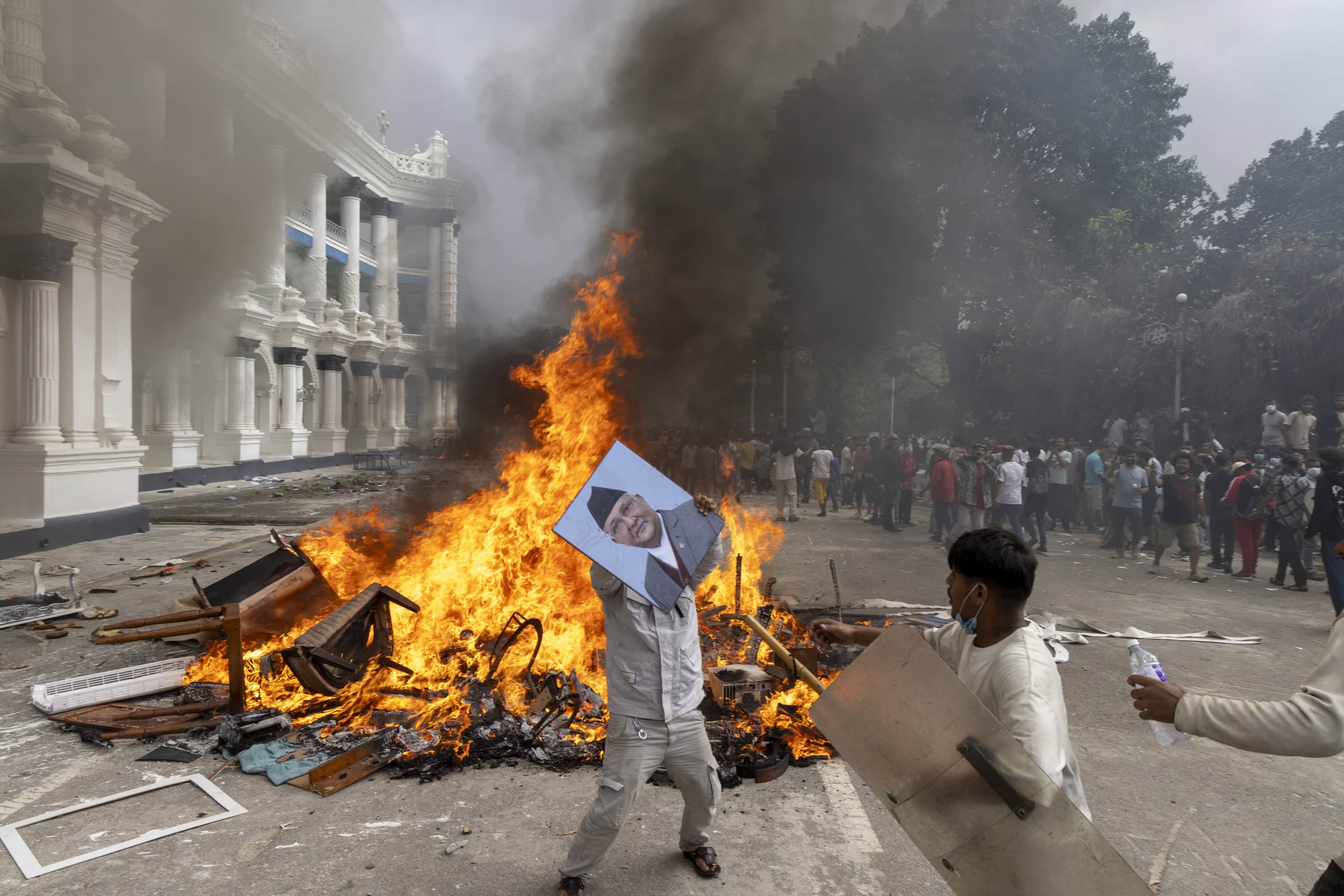Un manifestante se prepara para quemar una foto del primer ministro resignado K.P. Sharma Oli mientras asalta el palacio Singha Durbar, que alberga los edificios del gobierno y del parlamento, durante manifestaciones violentas en Katmandú, Nepal, el 09 de septiembre de 2025. Al menos 19 personas murieron y docenas resultaron heridas el 8 de septiembre durante manifestaciones contra la corrupción y una prohibición de las redes sociales del gobierno. (Protestas)