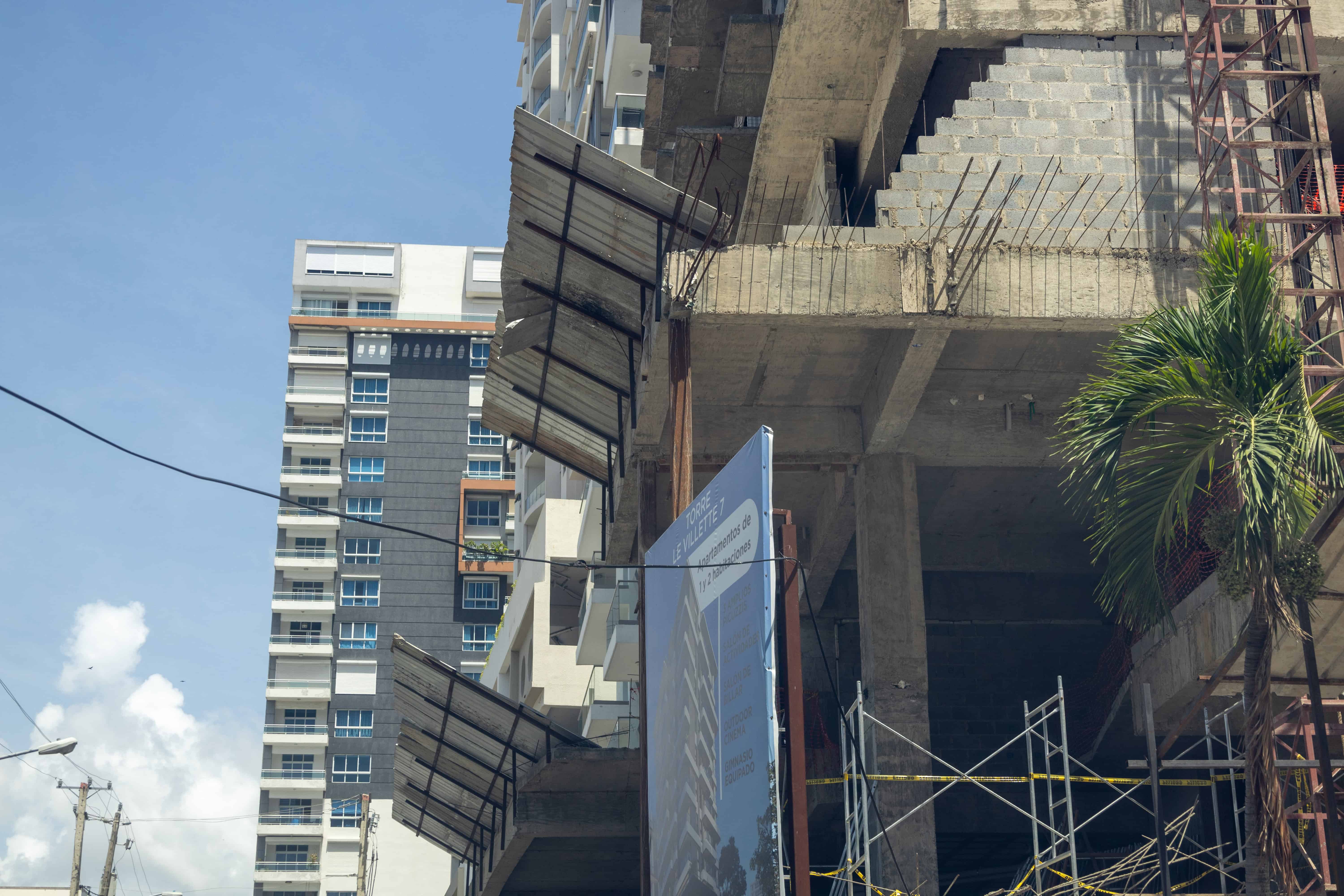 Construcción con pasarela peatonal que protege a los peatones de cualquier objeto que caiga de la construcción. 