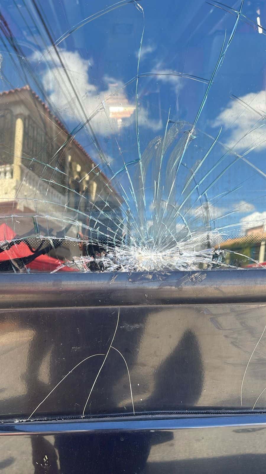 Uno de los vehículos que resultó con el cristal roto el sábado durante protesta en La Otra Banda por los apagones. 