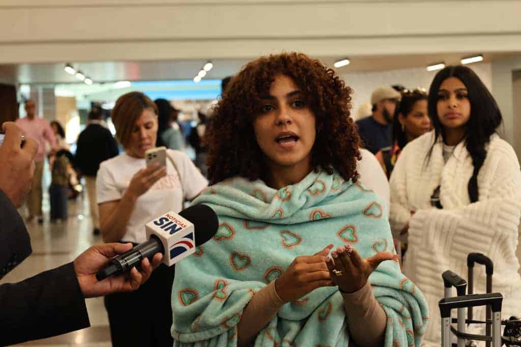 La pasajera Angel Lory mientras ofrece declaraciones a la prensa sobre la situación registrada en el AILA.