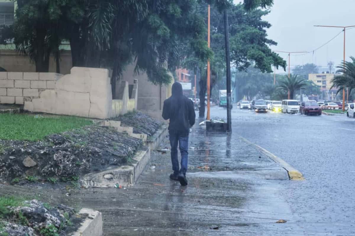 Un ciudadano camina bajo la lluvia. 