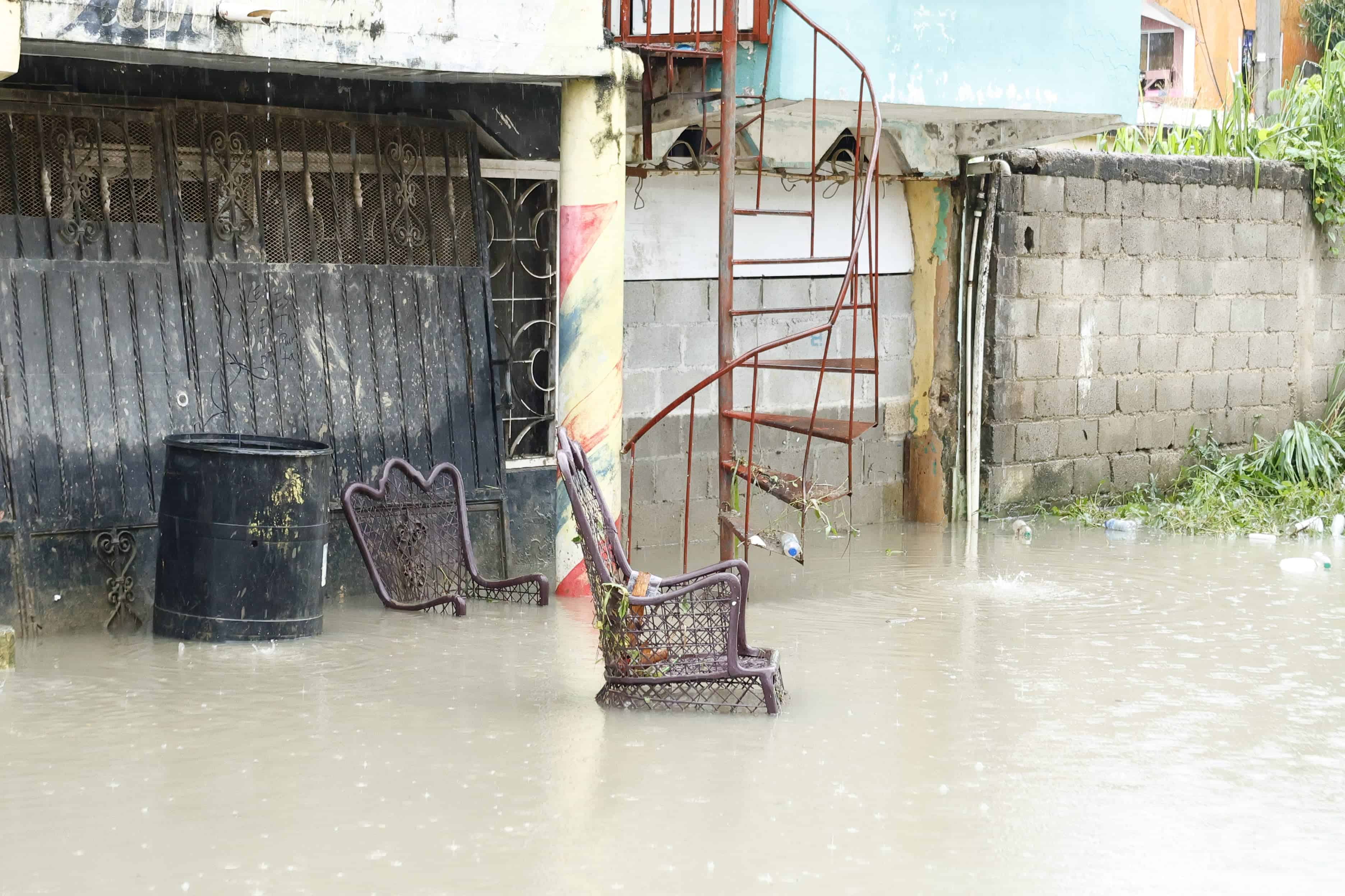 El agua cubre parcialmente una silla abandonada en una calle del sector Manoguayabo, en Santo Domingo Oeste.