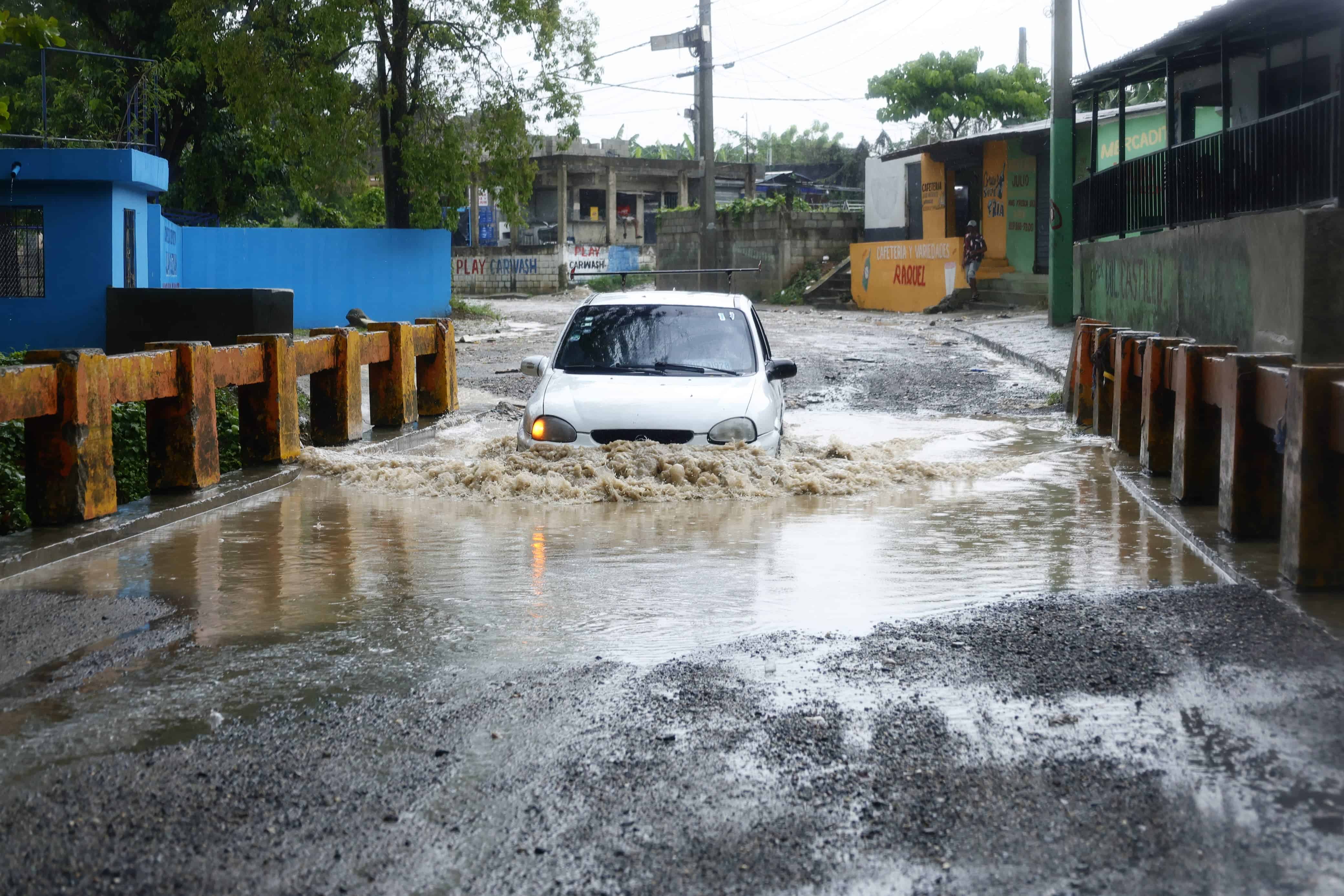 El conductor de un vehículo intenta cruzar un pequeño puente del sector Manoguayabo.