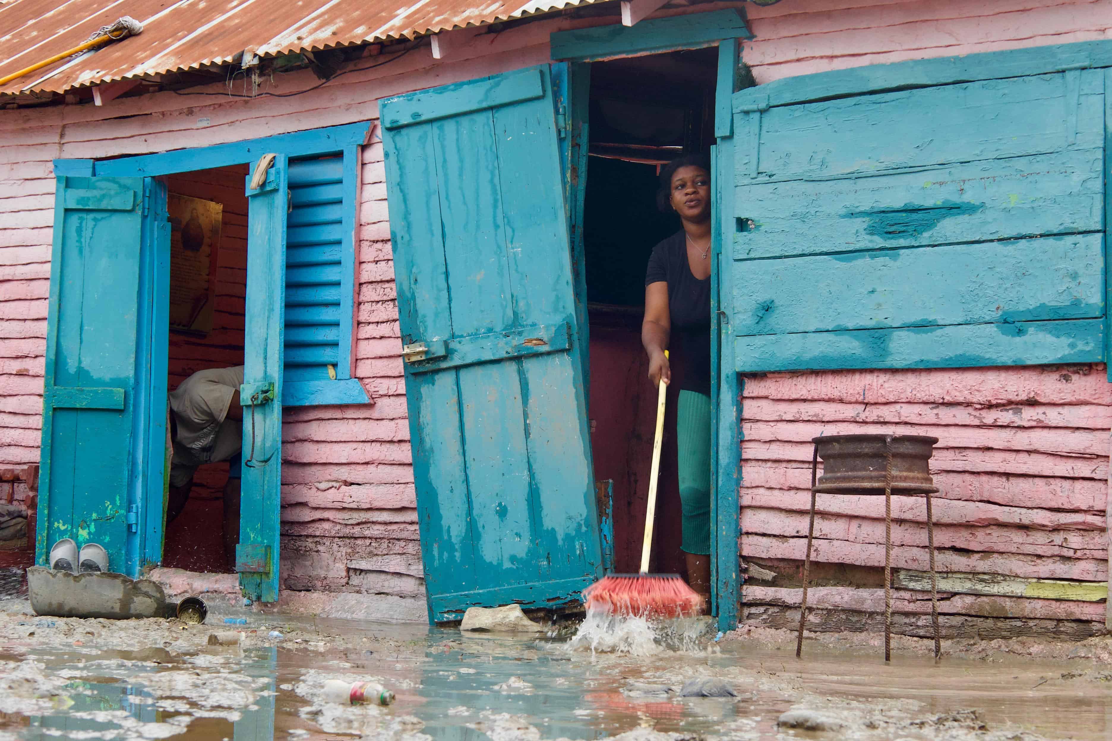 Una mujer saca agua de su casa en la comunidad Punta de Garza en El Rosario de Azua. 