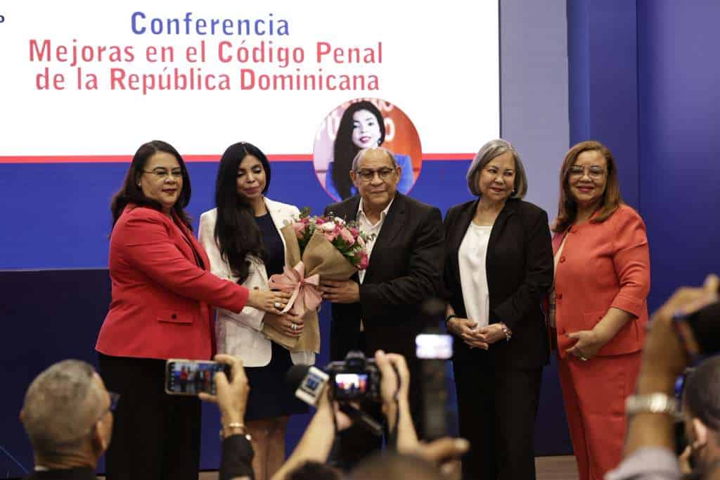 El director de Infotep, Rafael Santos Badía, entrega flores a la procuradora Yeni Berenice Reynoso. 