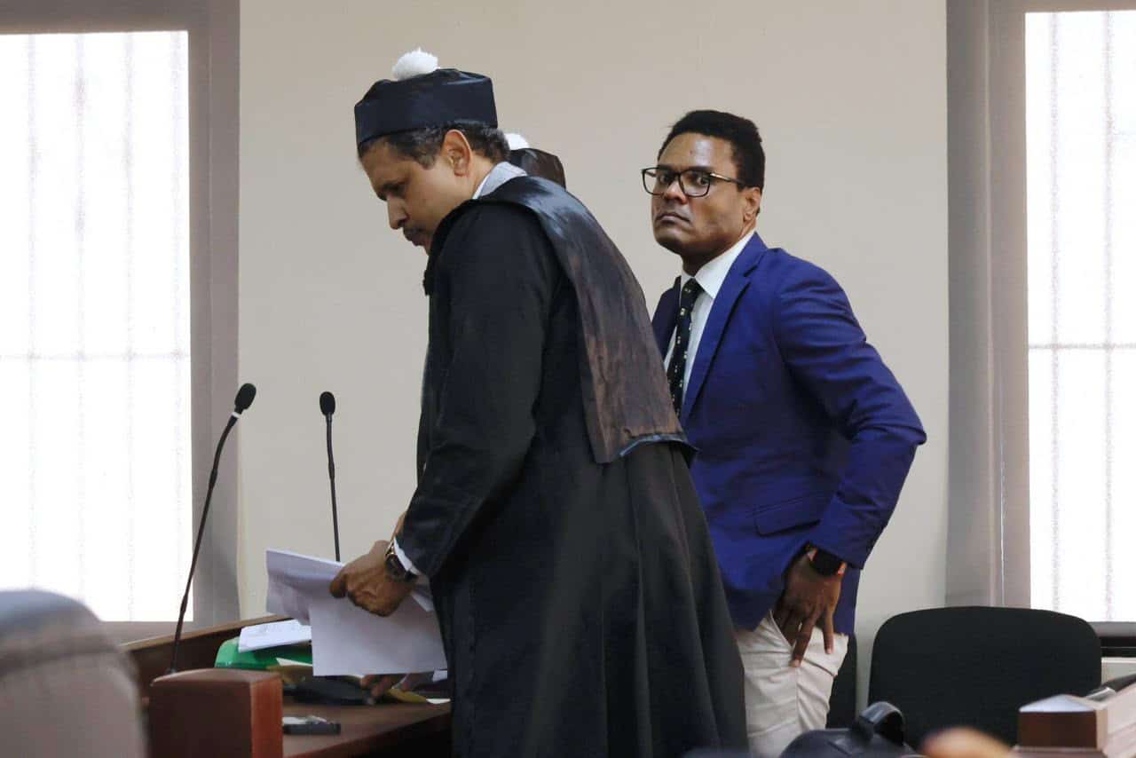 El exembajador Donni Santana Cuevas (derecha) junto a sus abogados en la Segunda Sala de la Corte Penal de la provincia San Cristóbal.