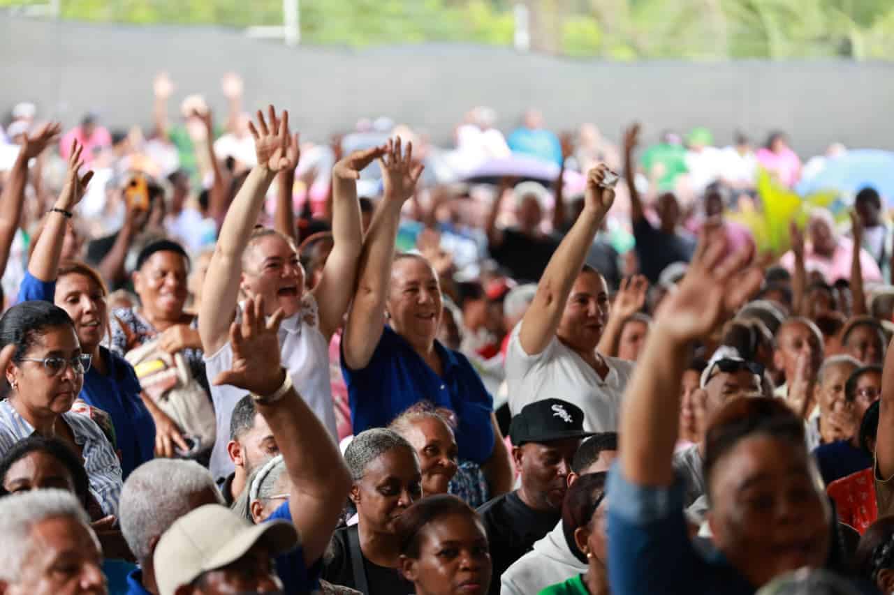 Grupo de asistentes y beneficiados asisten a la actividad de la entrega de títulos de propiedad.