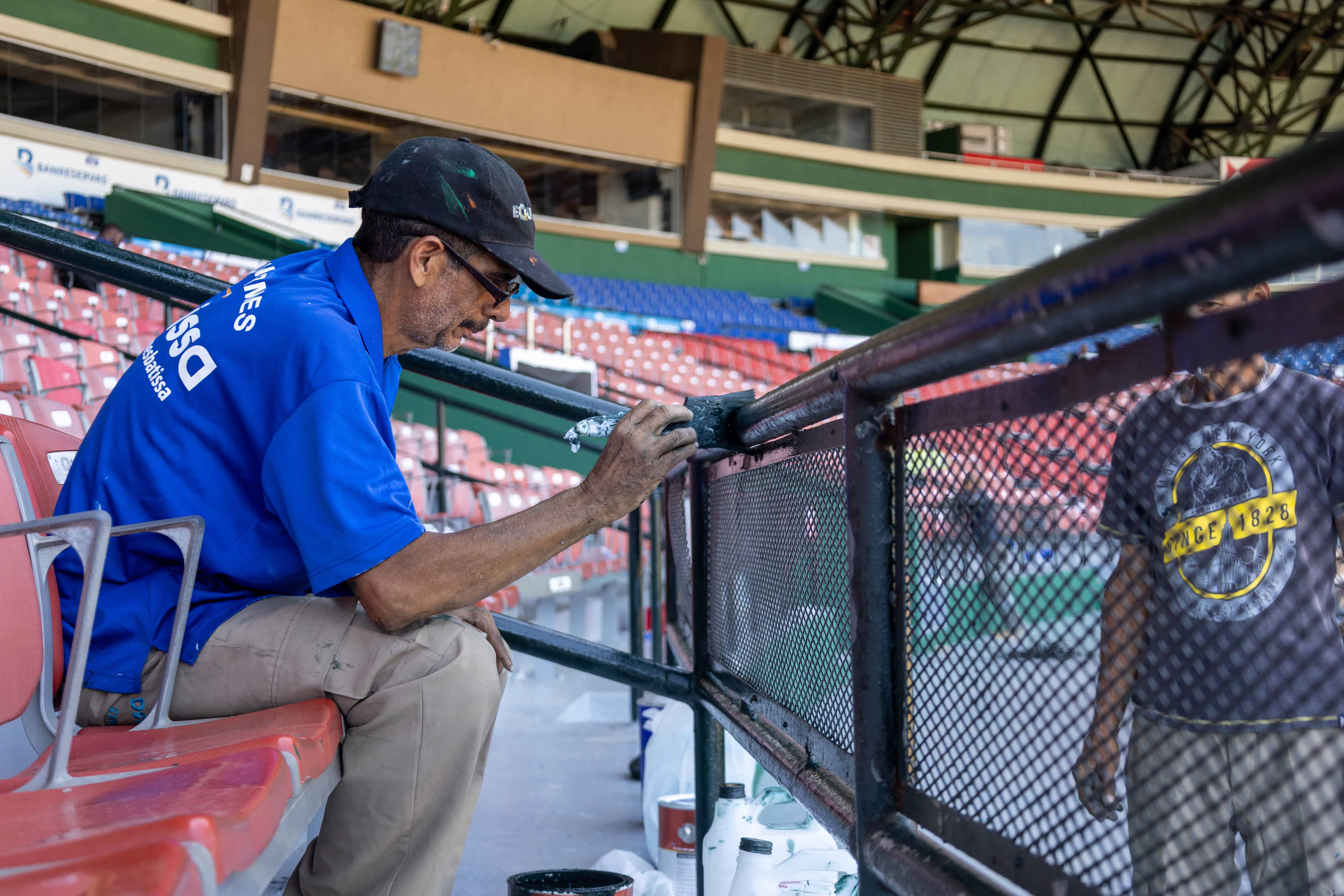 Un obrero pinta la verja de los palcos AA del Estadio Quisqueya al mediodía de este viernes 10 de octubre de 2025.