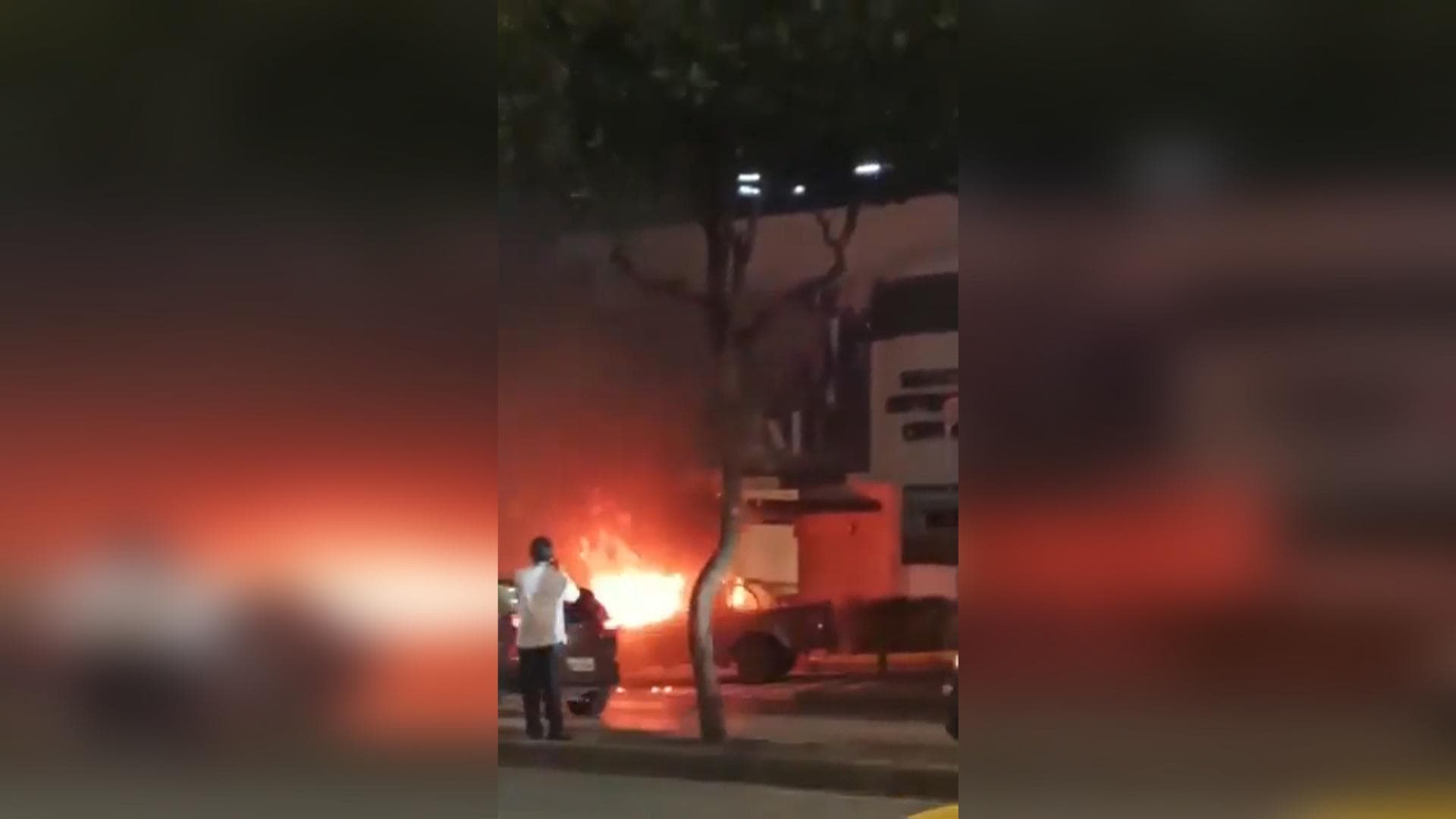 Captura de video que muestra un vehículo incendiándose afuera de un centro comercial este martes, en Guayaquil (Ecuador). <br>