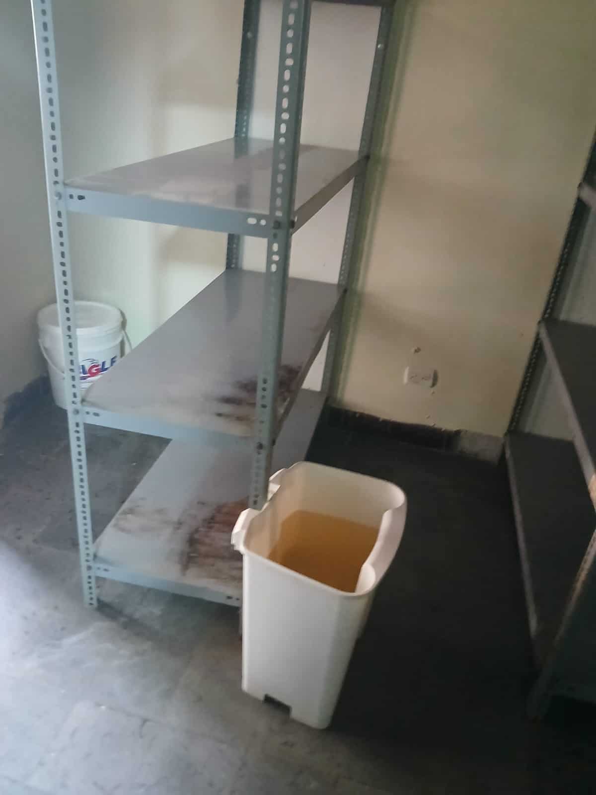 Un zafacón con agua sucia acumulada por filtraciones.