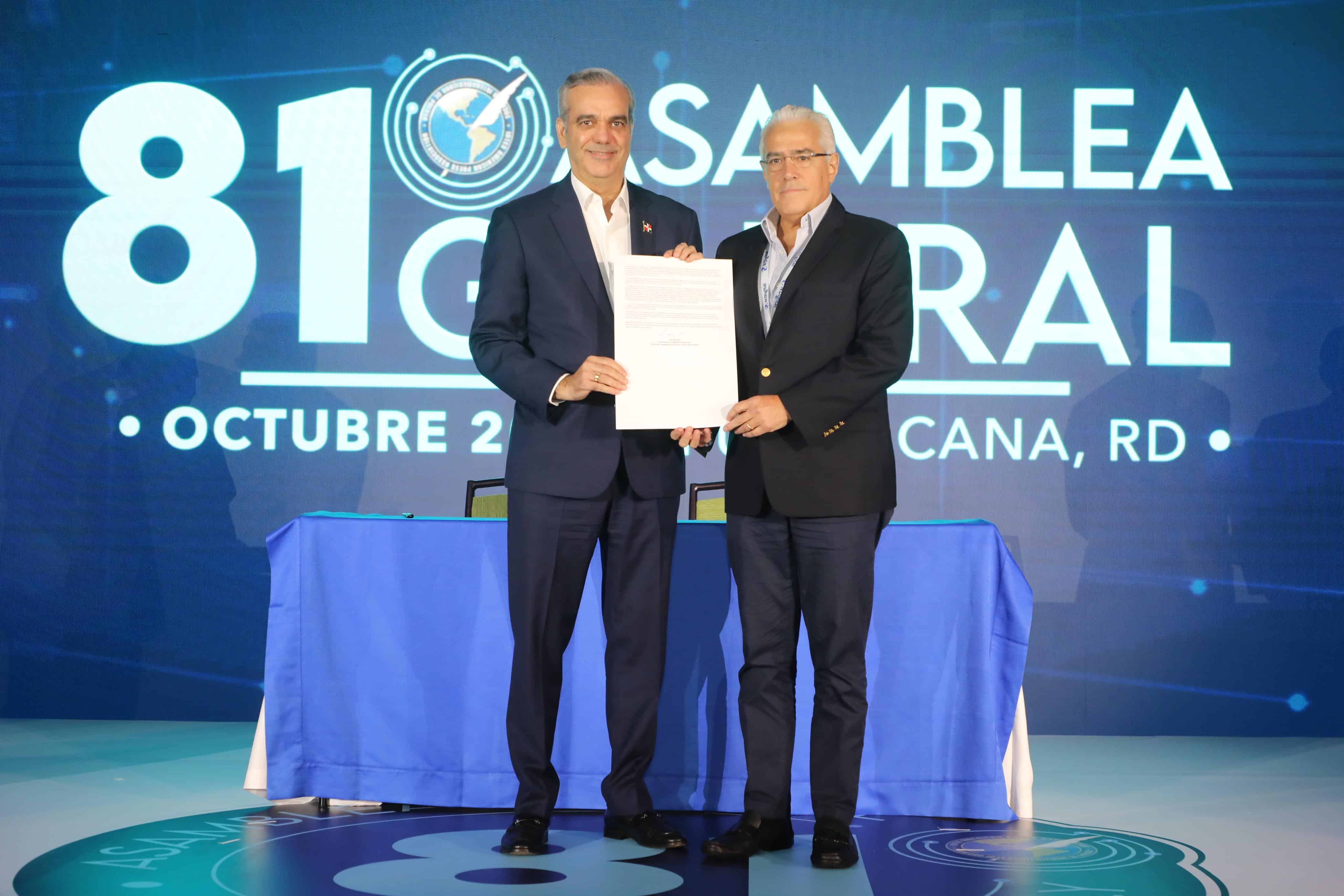 El presidente Luis Abinader y el presidente de la SIP, José Roberto Dutriz presentan el documento ya firmado. 