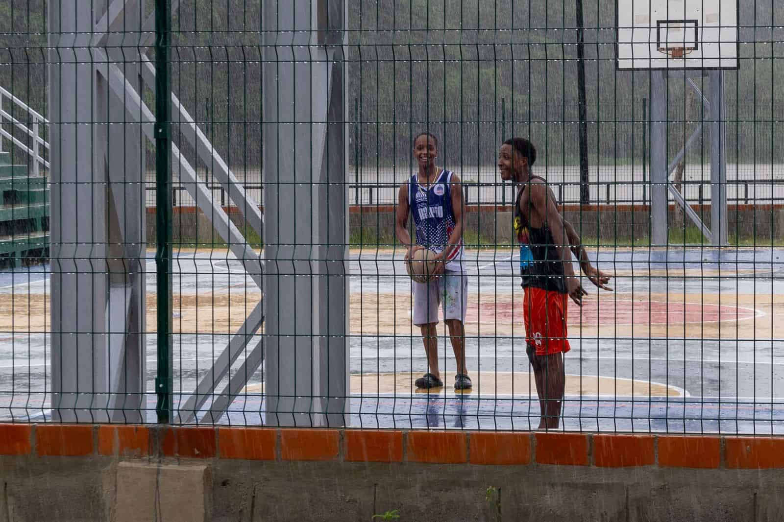 Adolescentes jugando baloncesto en medio de la lluvia en La Ciénaga este 27 de octubre de 2025.