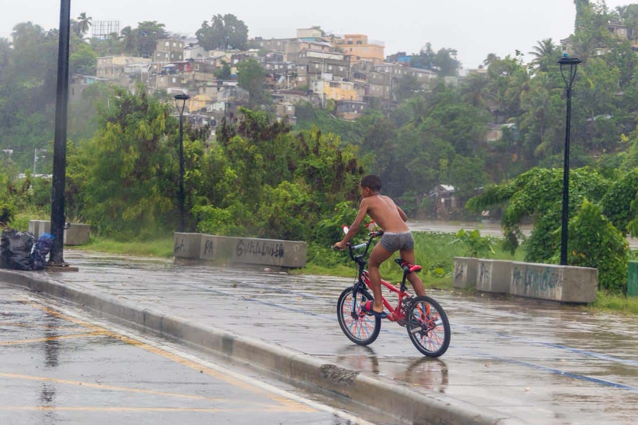 Niño en bicicleta en medio de la lluvia en La Ciénaga este 27 de octubre de 2025.