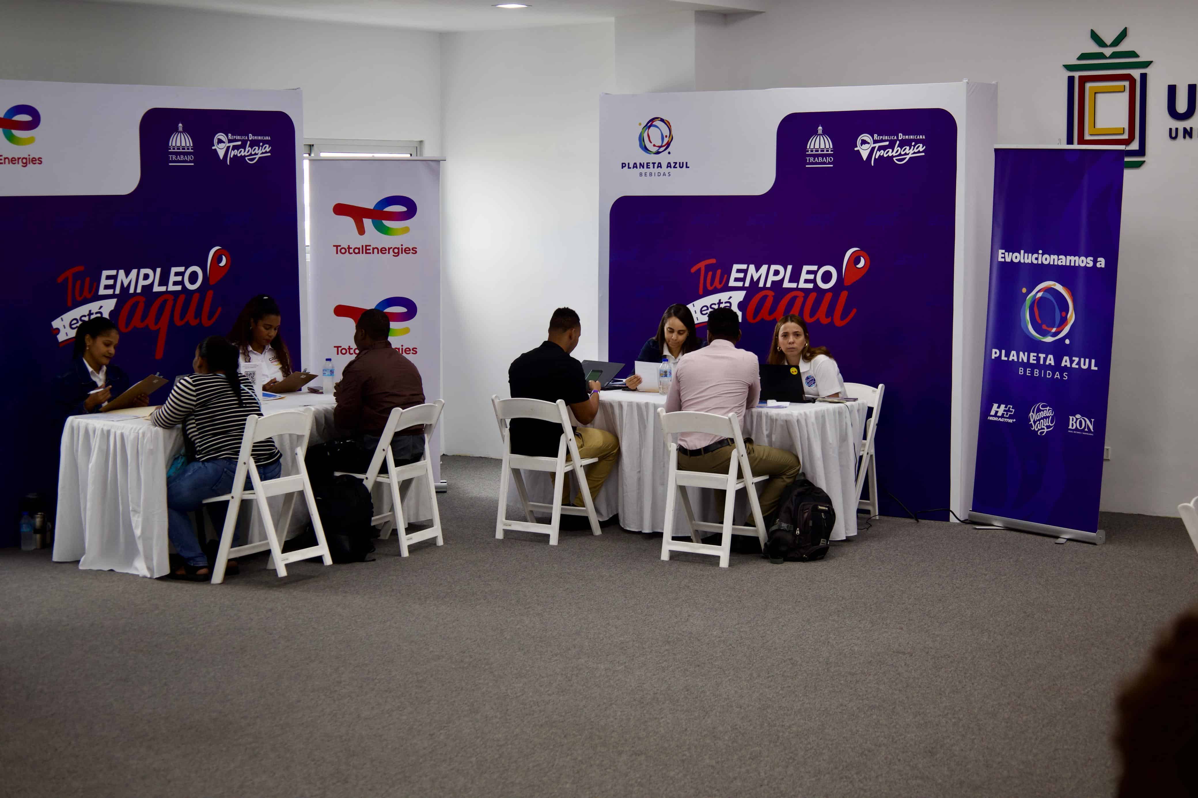 Postulantes conversan con el personal de la feria y entregan sus documentos. 