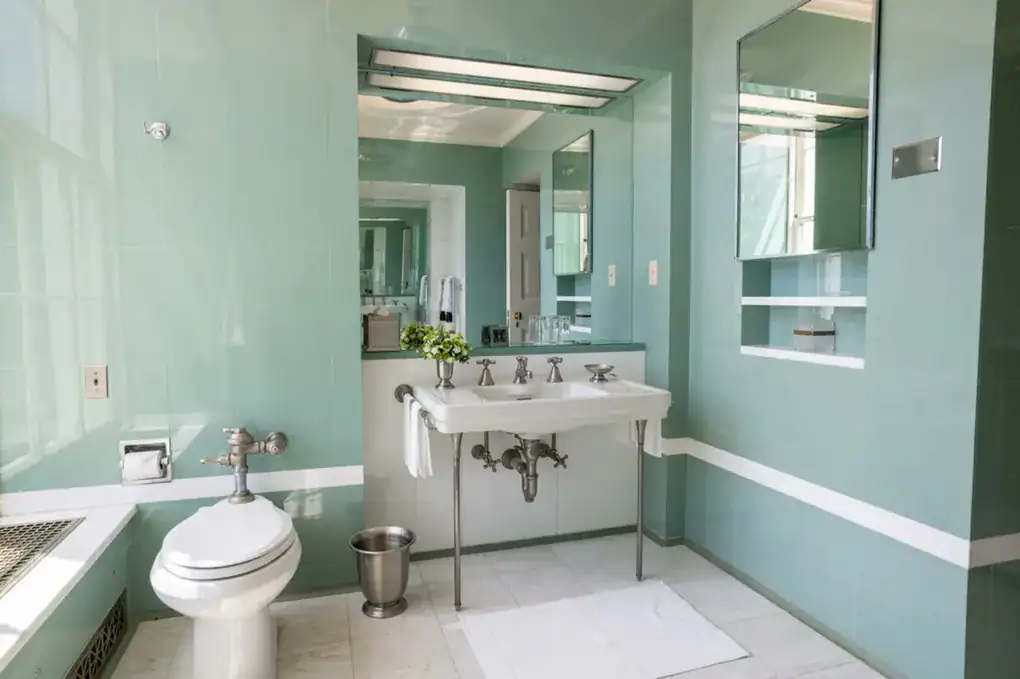 Baño Lincoln de la década de 1940 con un estilo art déco de azulejos verdes.