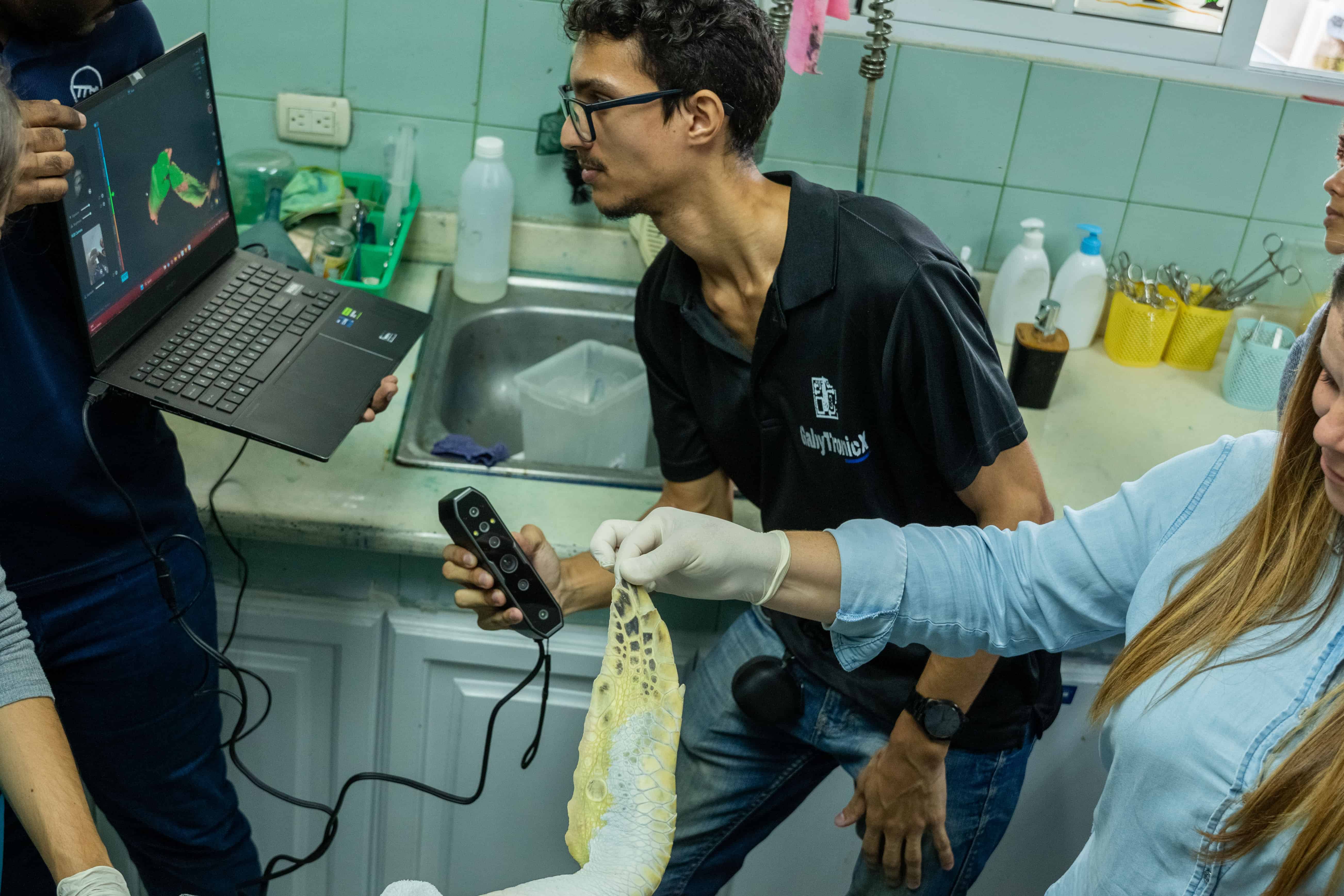 El equipo mixto del Acuario Nacional y del ITLA miden la aleta sana como referencia para la prótesis.