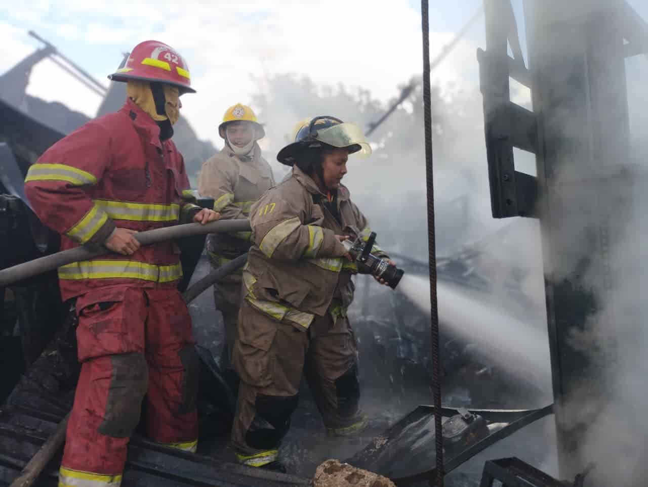 Bomberos mientras intentan controlar el fuego en la fábrica de plásticos en la comunidad Las Charcas de Santiago. 