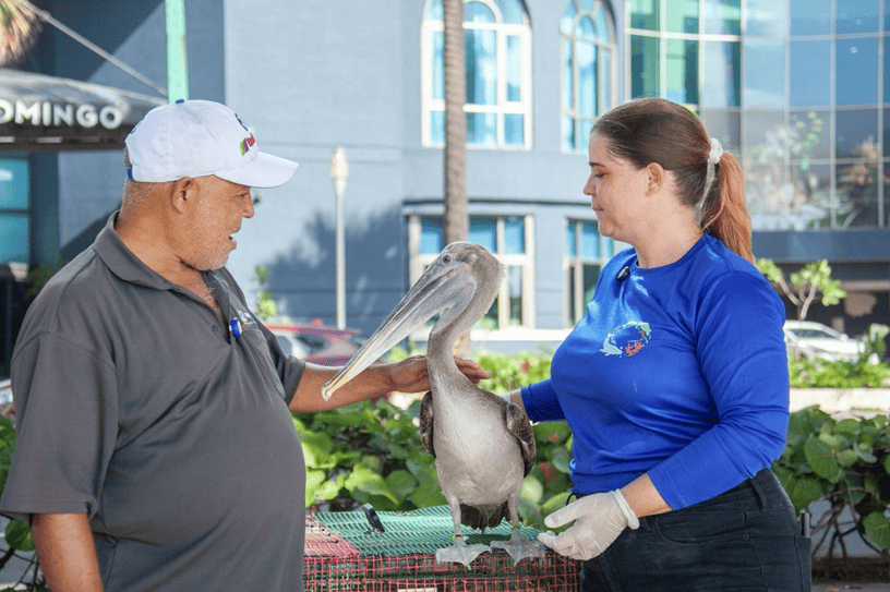 Jazmín León con Pescador y uno de los pescadores que lo rescató. 