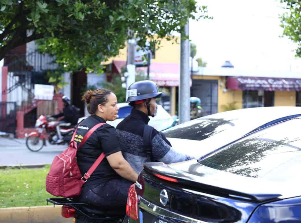 Un motorista con una pasajera sin casco.