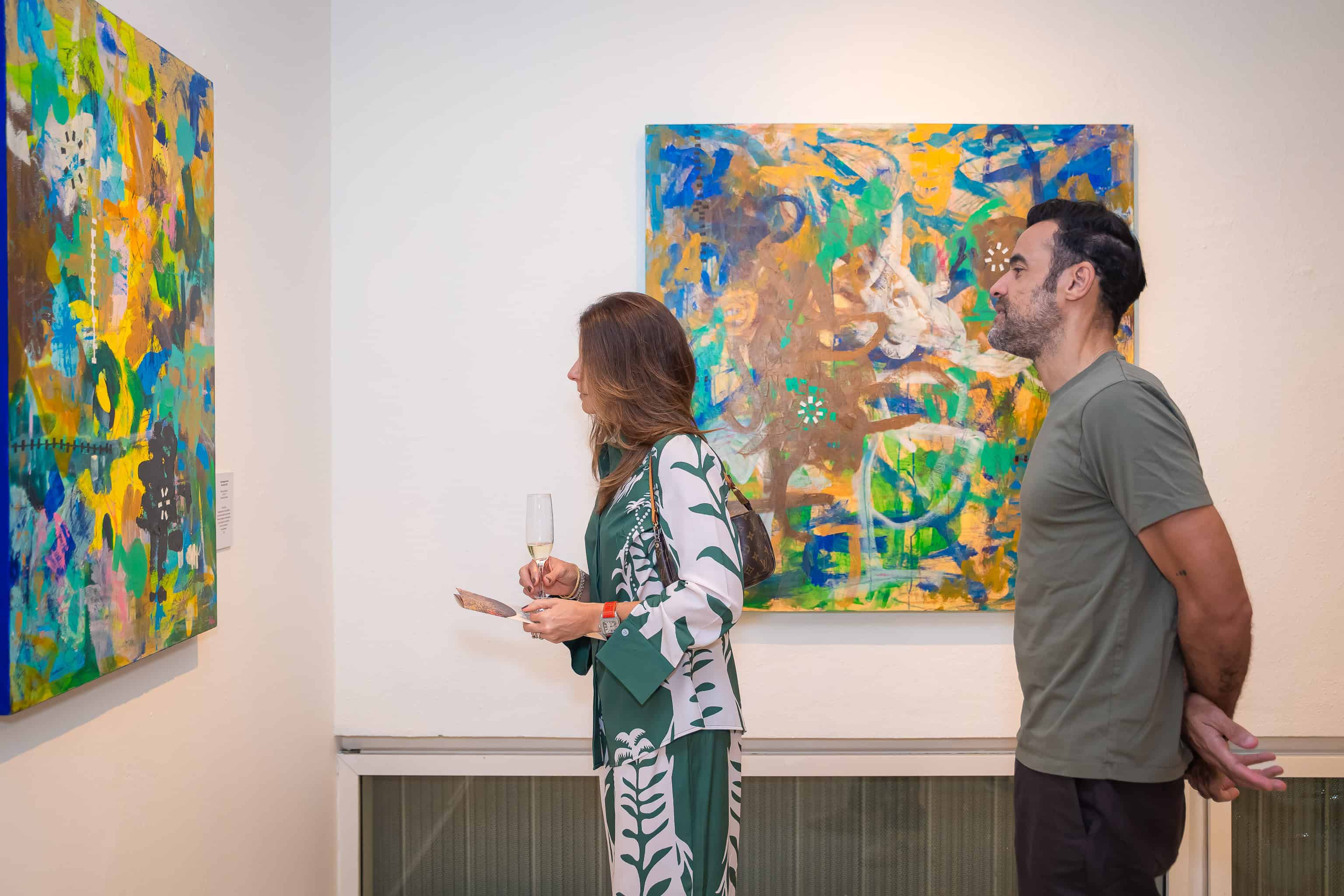 Ana Capano observa las obras de Aida Vásquez.