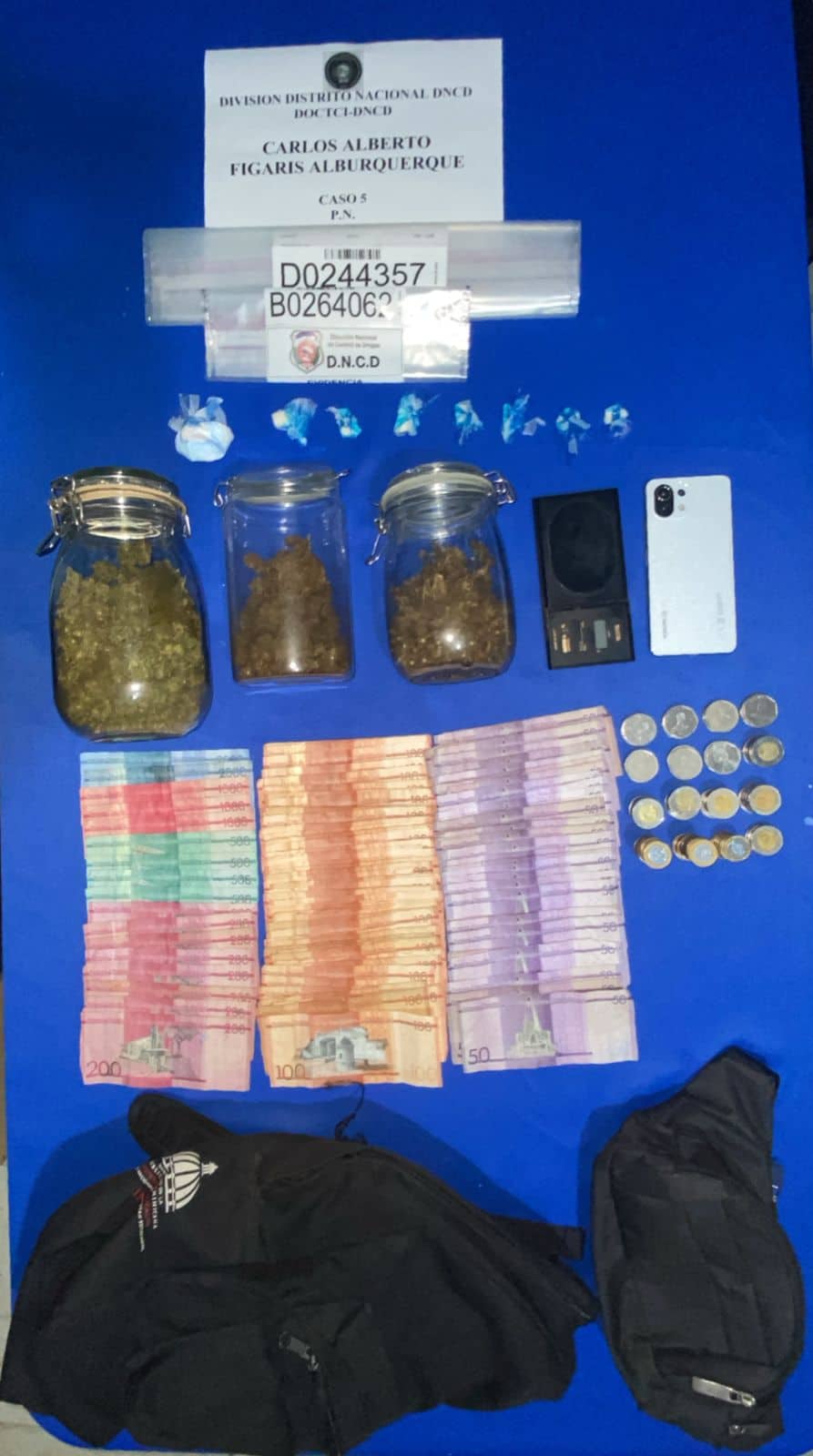 Evidencias ocupadas por la DNCD durante un operativo, incluyendo dinero en efectivo, sustancias presumiblemente narcóticas y otros objetos.
