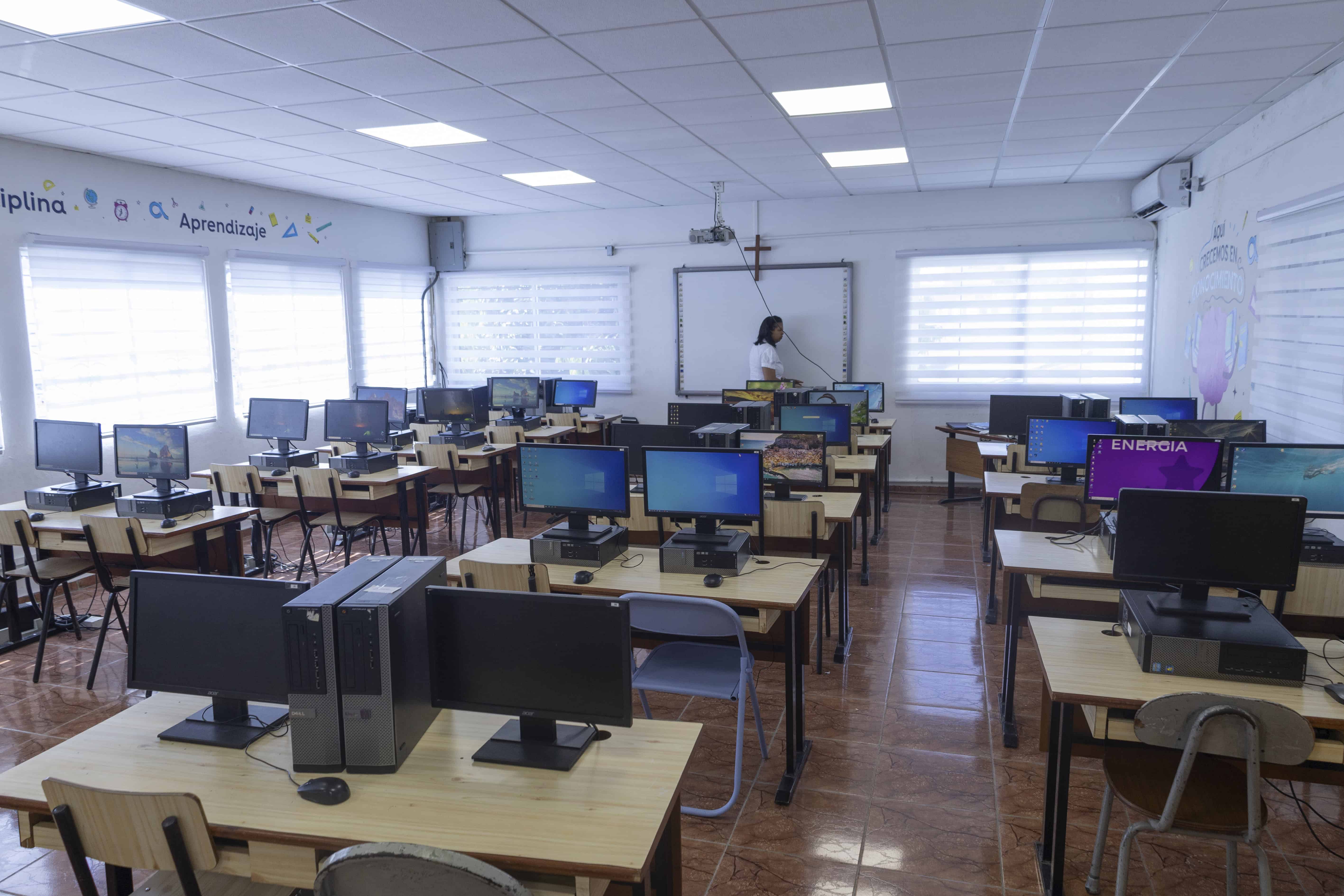 Estudiantes reciben clases de informática en un aula donada por Altice.