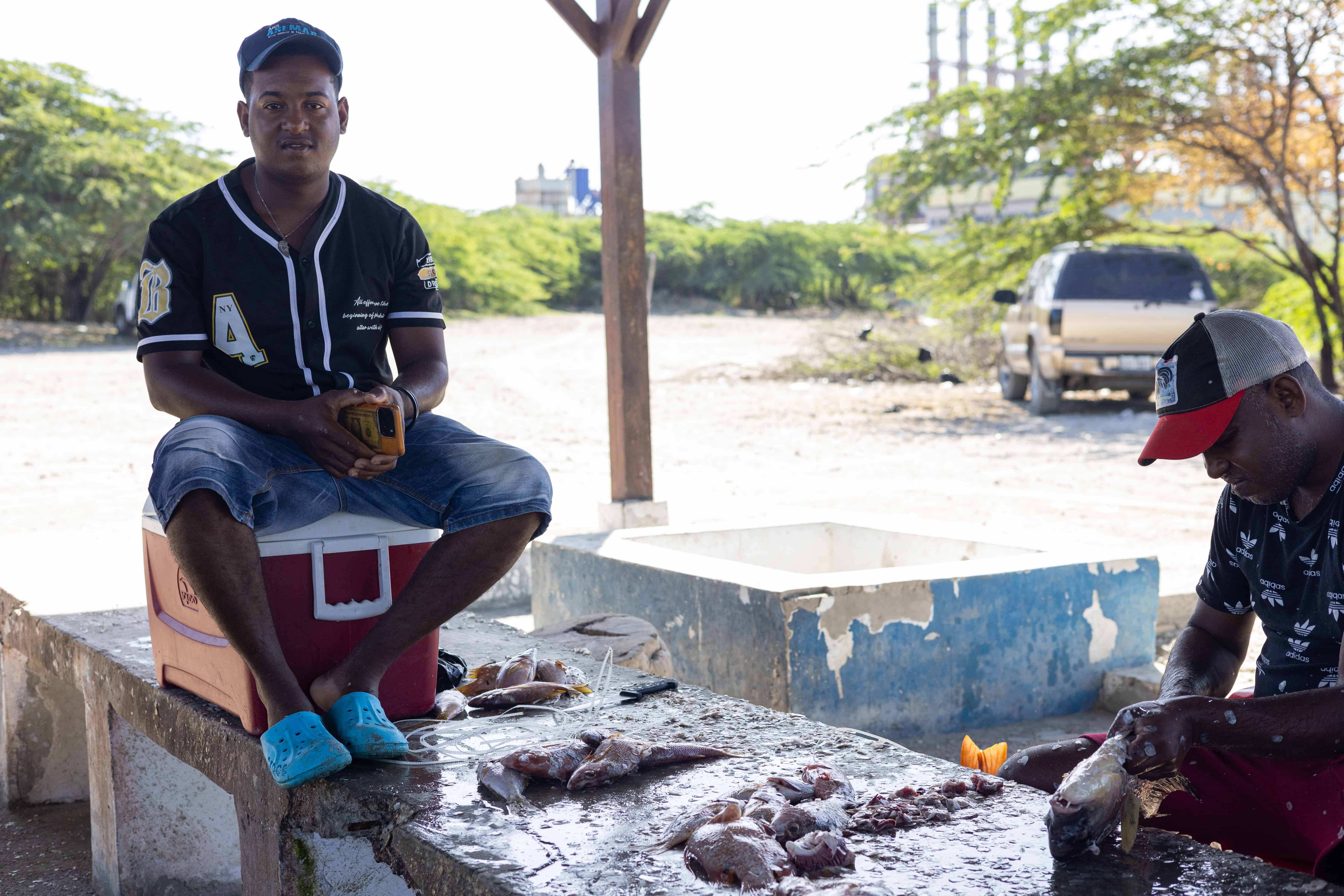 Anderson López, vendedor de pescado en la playa Los Negros, asegura que el humo y el calor de las barcazas han espantado a los visitantes y reducido drásticamente sus ventas.